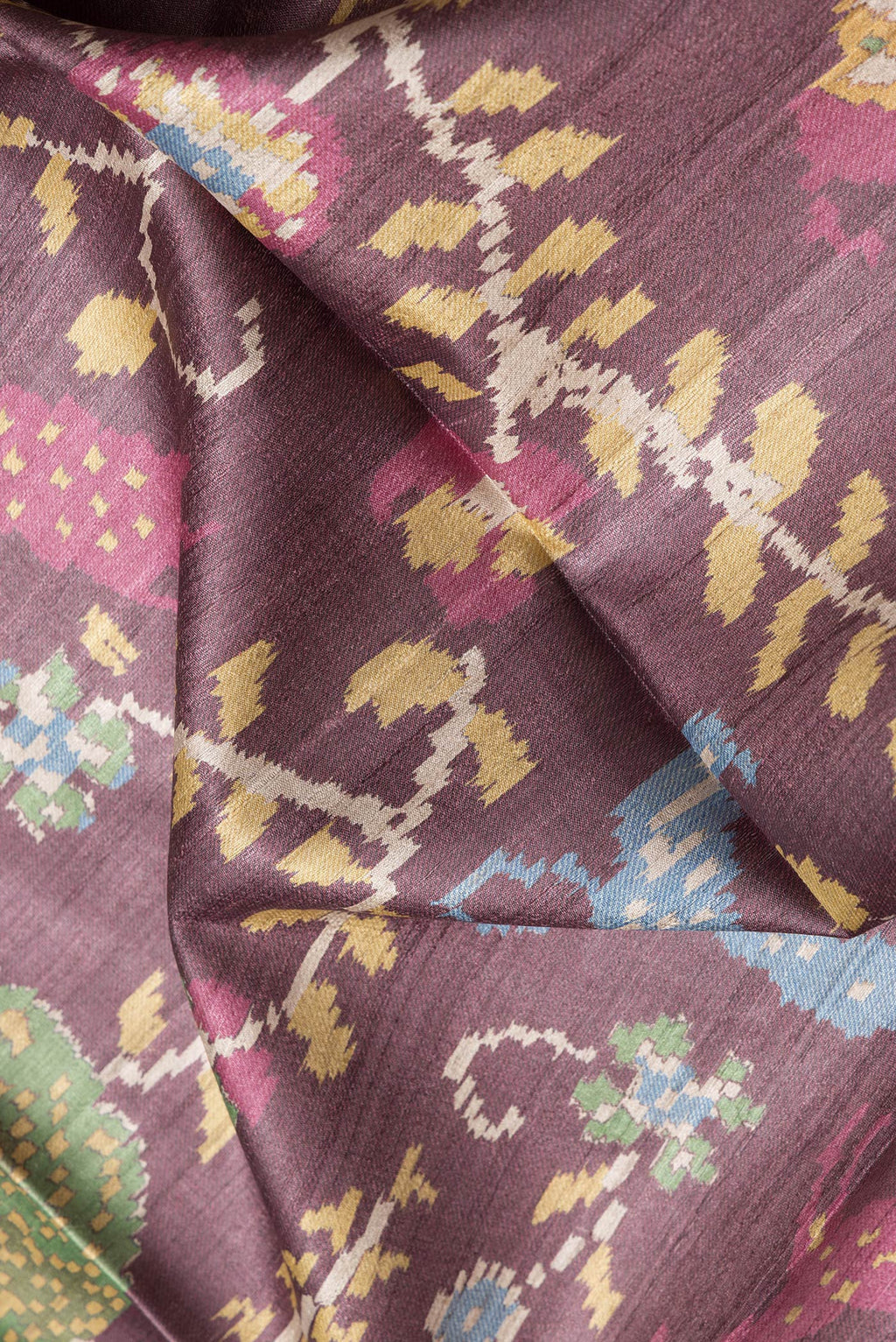 Close up of Burgundy Dual Tone Tussar Silk Saree with Ikat Print on the body and Plain Border.  displaying folds