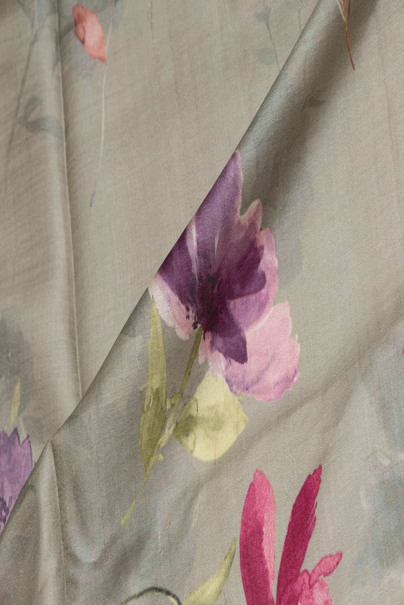 Close up of Green Tussar Silk Saree with Floral Print on the body and Embroidery Border displaying folds