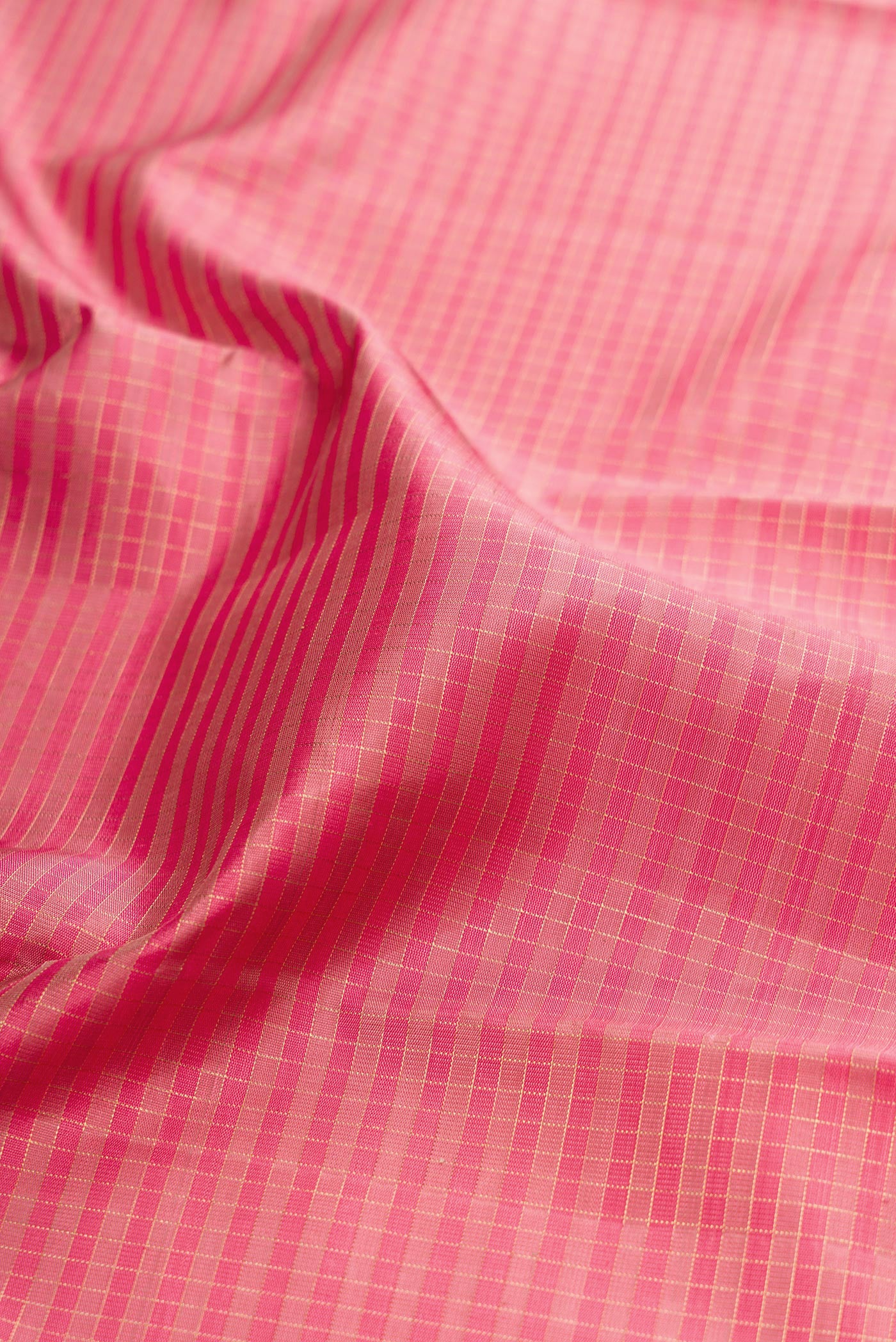 Close up of Pure Silk Pure Zari Pink Kanchipuram Saree with Checked design on the body and Zari Border.  displaying folds