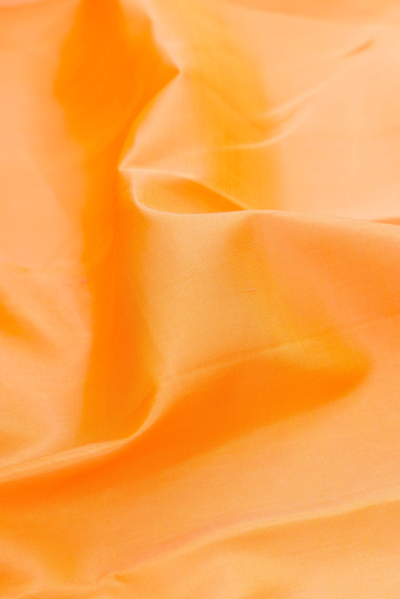 Close up of Orange Kanjivaram Silk Saree with Plain Body and Temple Border.  displaying folds