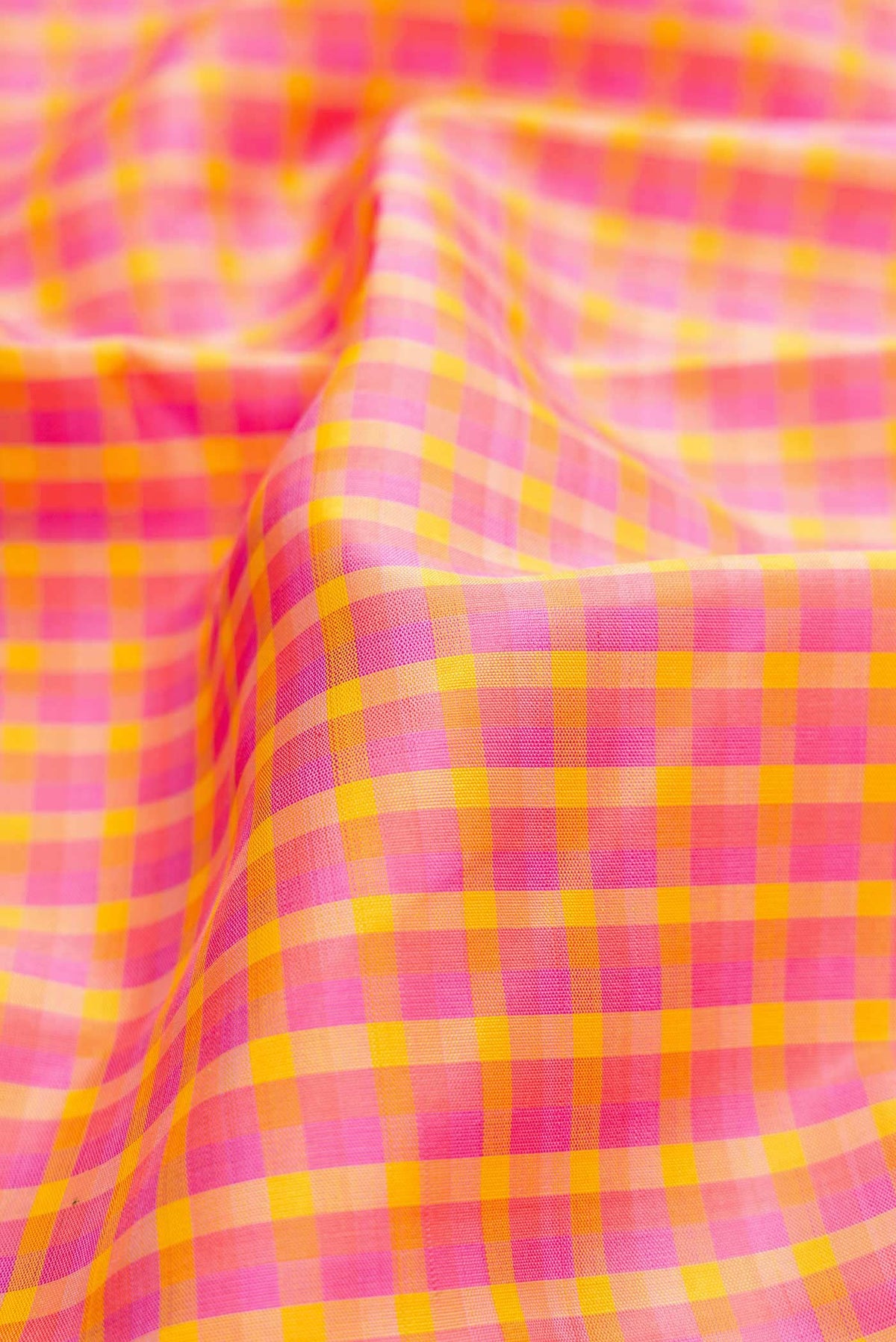 Close up of Pure Silk Pure Zari Pink, Purple and Yellow Color Kanchipuram Saree with Checked design on the body and Zari Border displaying folds
