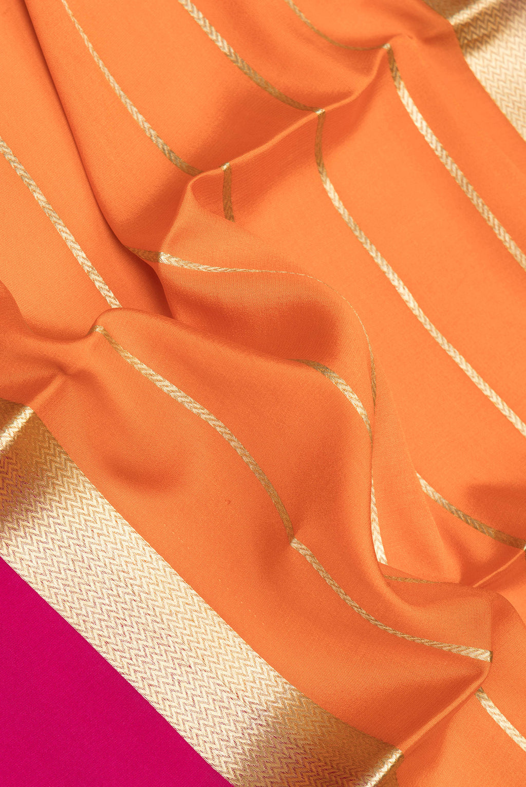 Close up of Orange Mysore Crepe Saree with Stripes on the body and Zari Border.  displaying folds