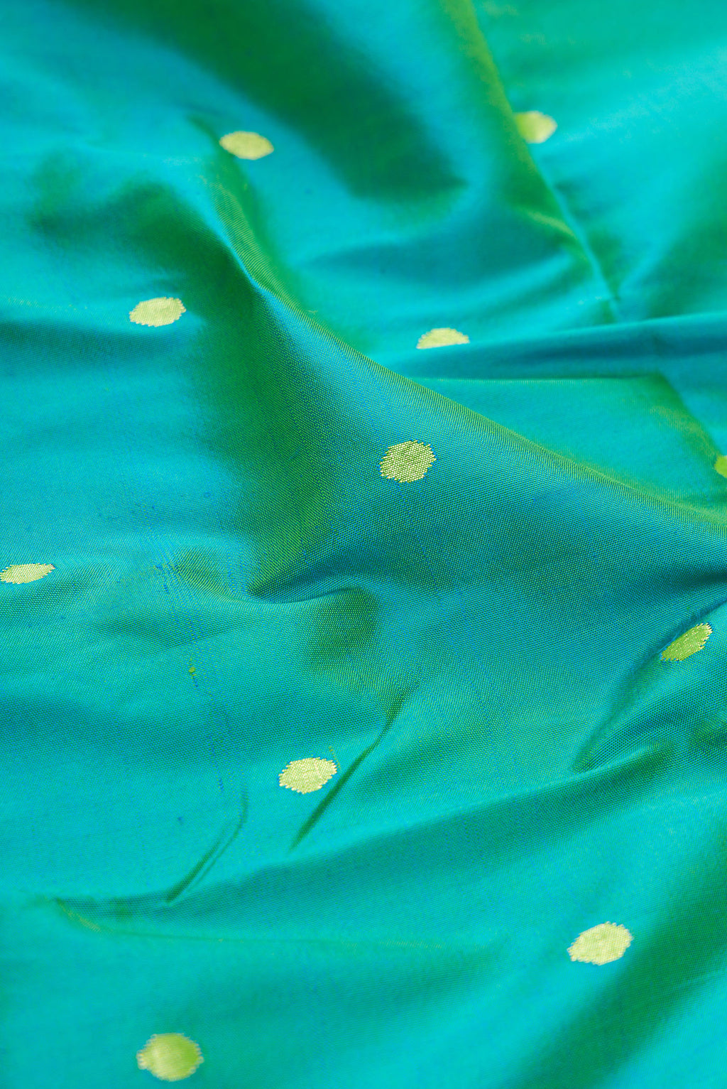 Close up of Peacock Blue Dual Tone Paithani Silk Saree with Zari Butta on the body and Paithani Border.  displaying folds
