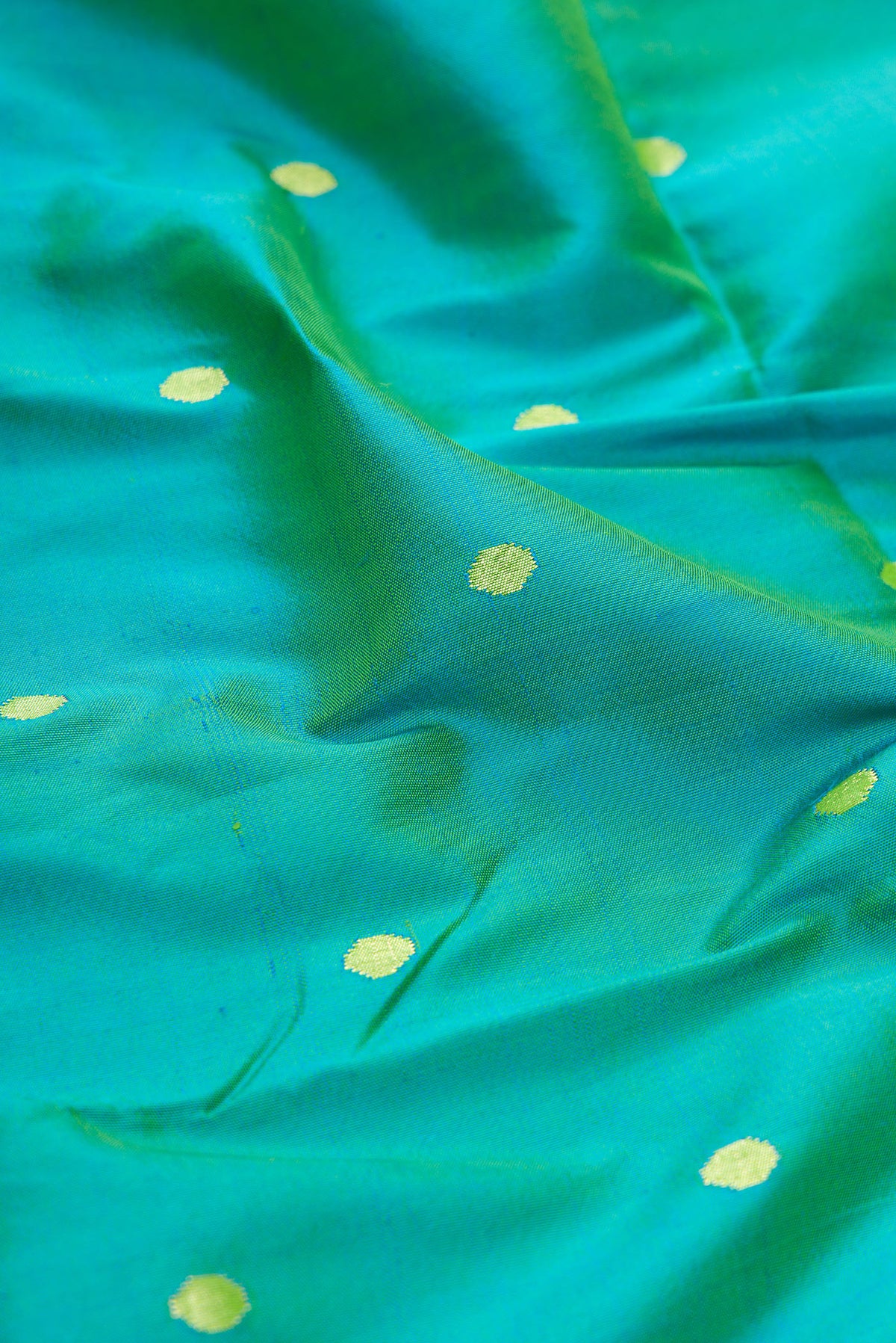 Close up of Peacock Blue Dual Tone Paithani Silk Saree with Zari Butta on the body and Paithani Border.  displaying folds