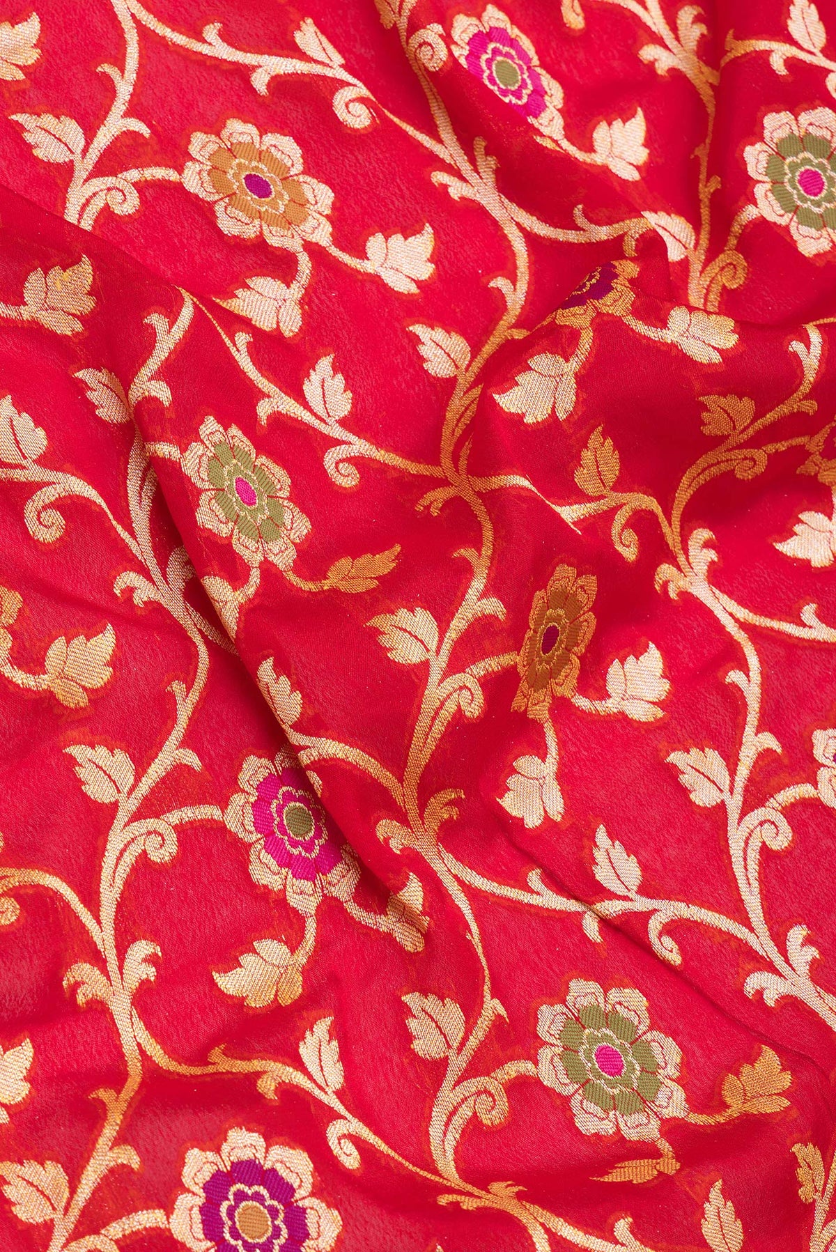 Close up of Red Banarasi Georgette Saree with Zari Brocade on the body and Zari And Thread Border.  displaying folds