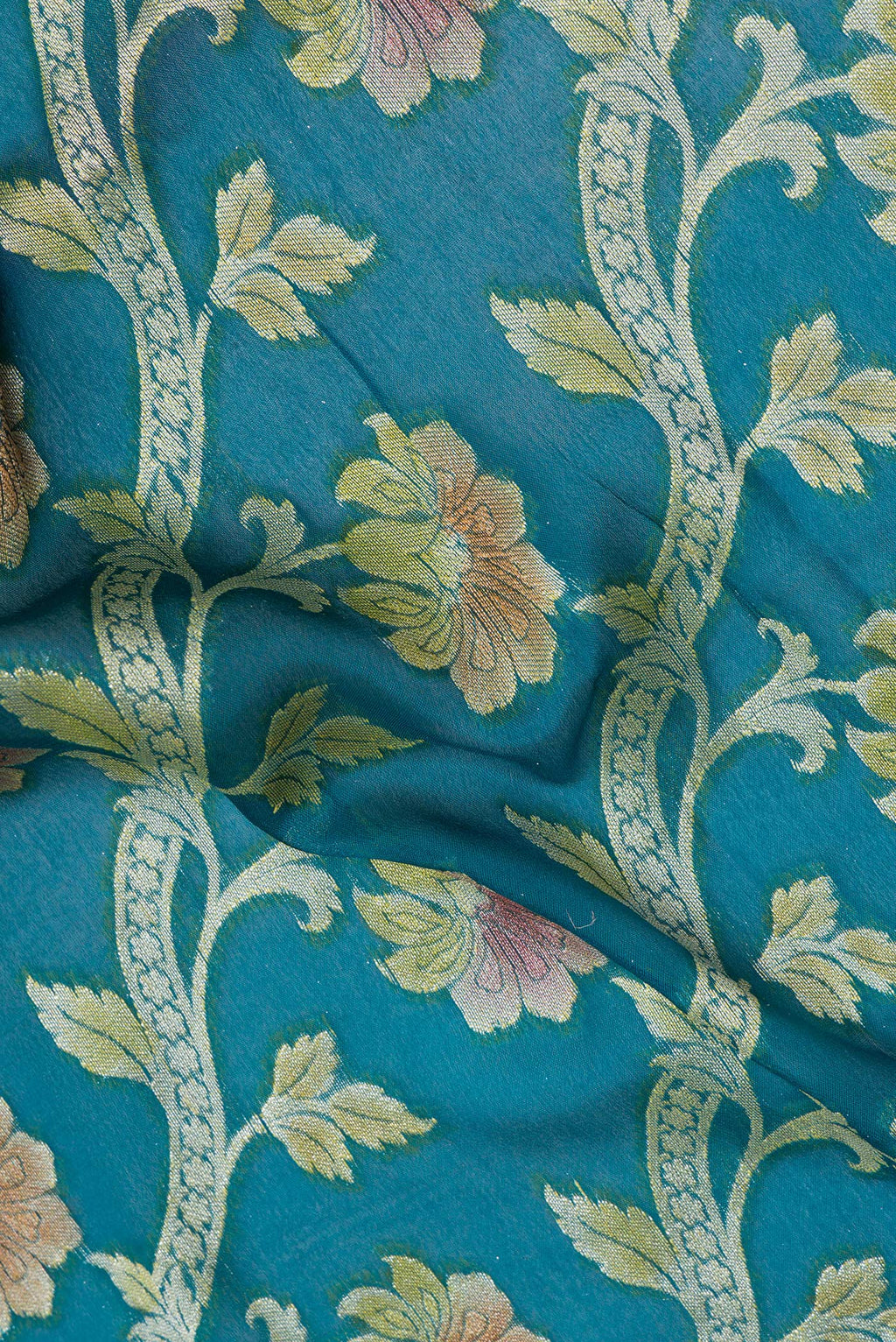 Close up of Peacock Blue Banarasi Georgette Saree with Zari And Thread Butta on the body and Zari Border.  displaying folds