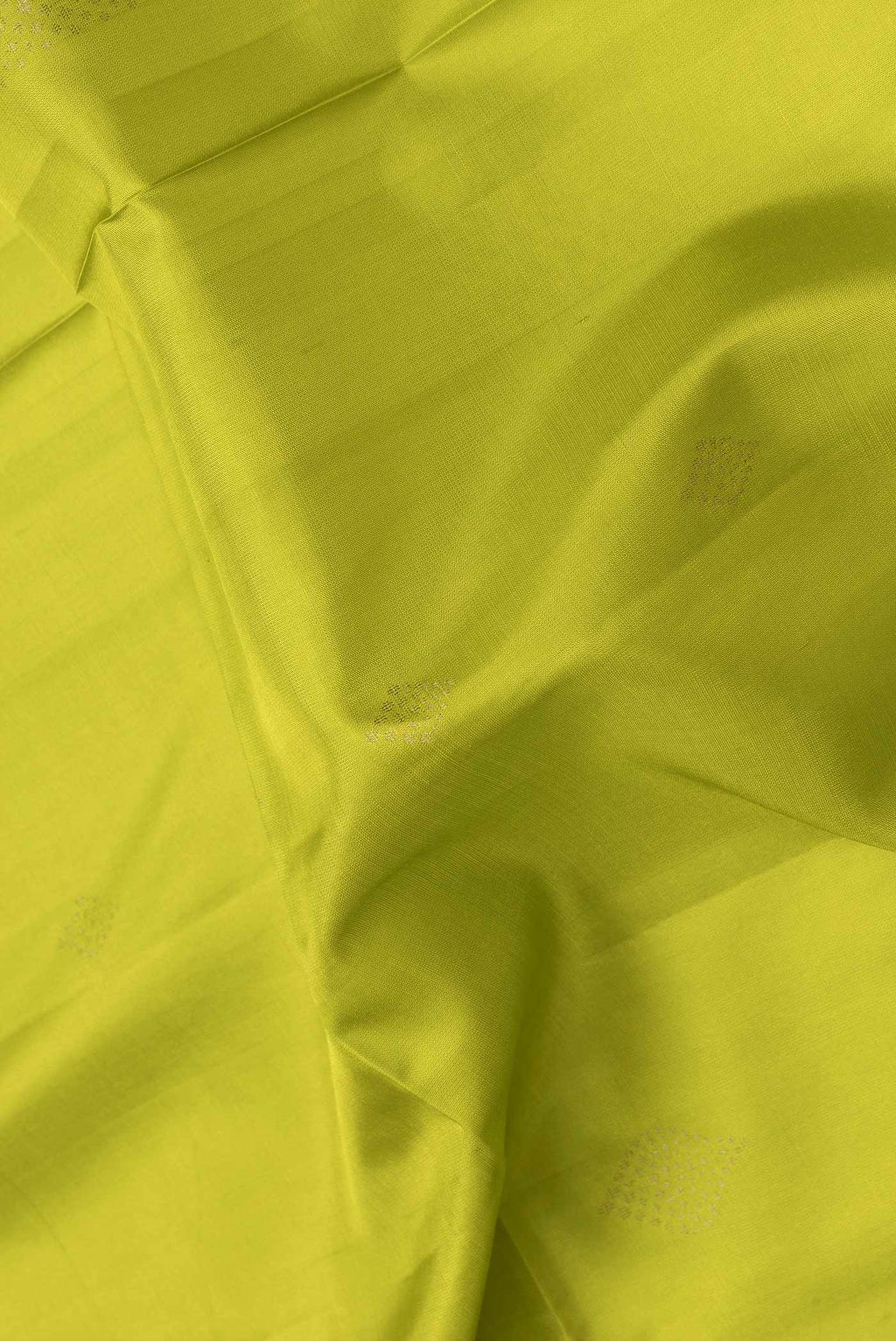 Close up of Parrot Green Dual Tone Soft Silk Saree with Zari Butta on the body and Thread Border.  displaying folds