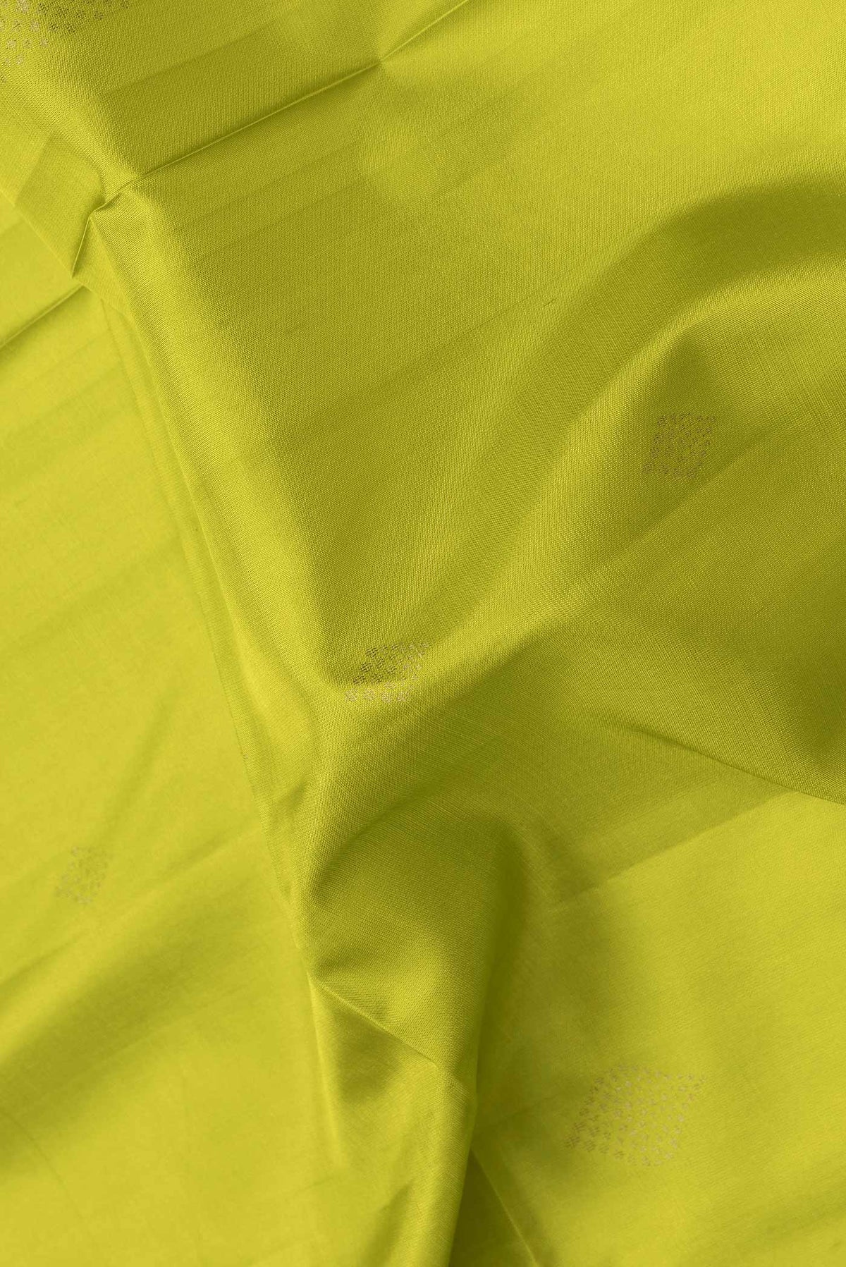 Close up of Parrot Green Dual Tone Soft Silk Saree with Zari Butta on the body and Thread Border.  displaying folds