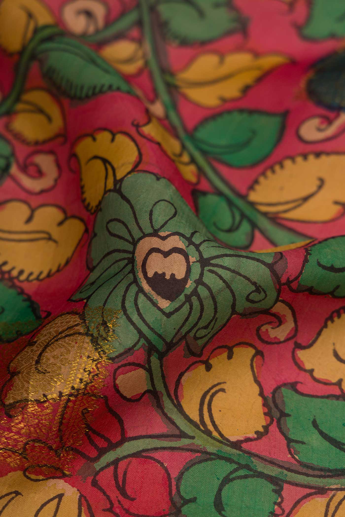 Close up of Peach Dual Tone Kanchipuram Silk Saree with kalamkari Print on the body and Fancy Border.  displaying folds