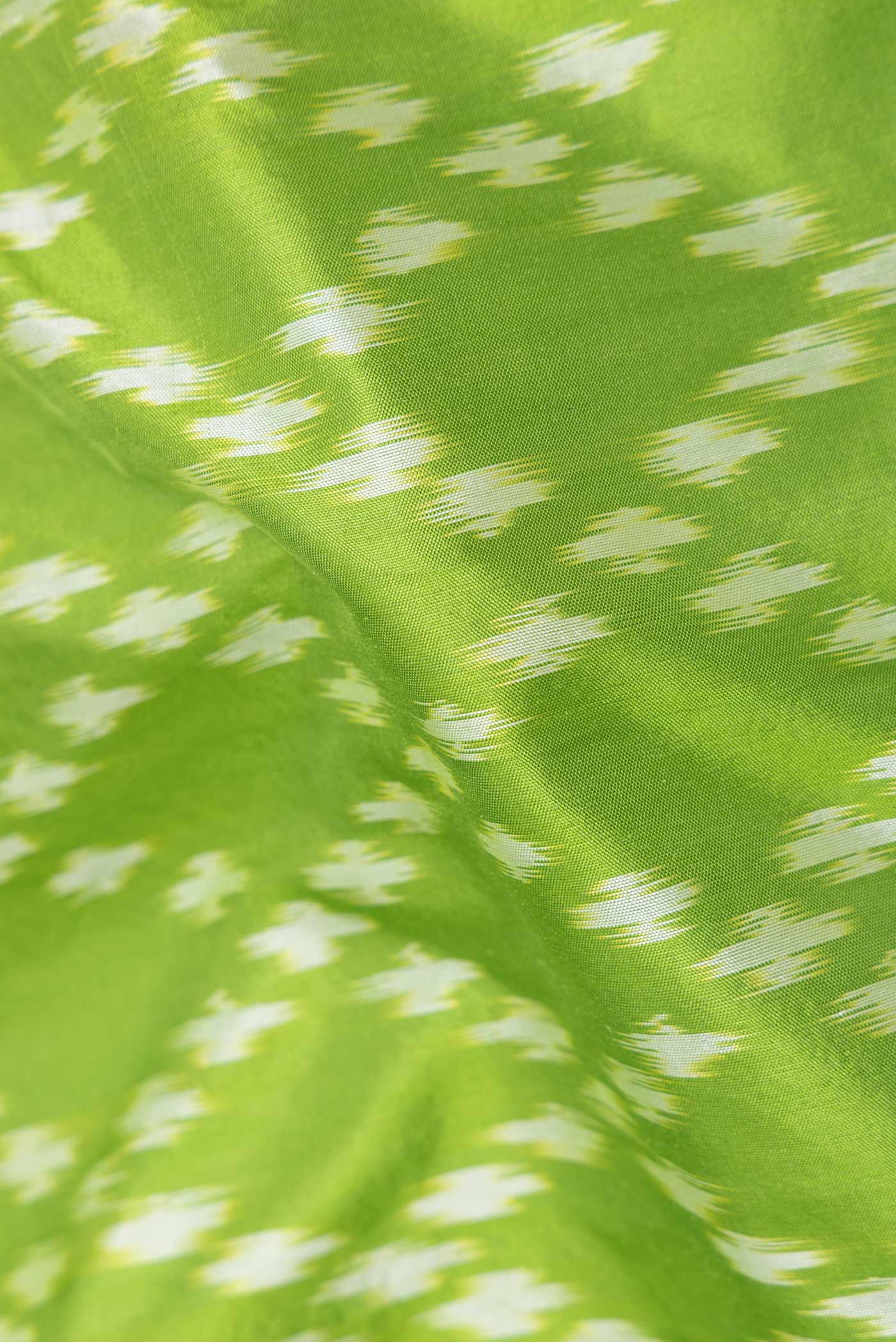 Close up of Parrot Green Dual Tone Double Ikat Saree with Ikat Print on the body and Zari Border displaying folds