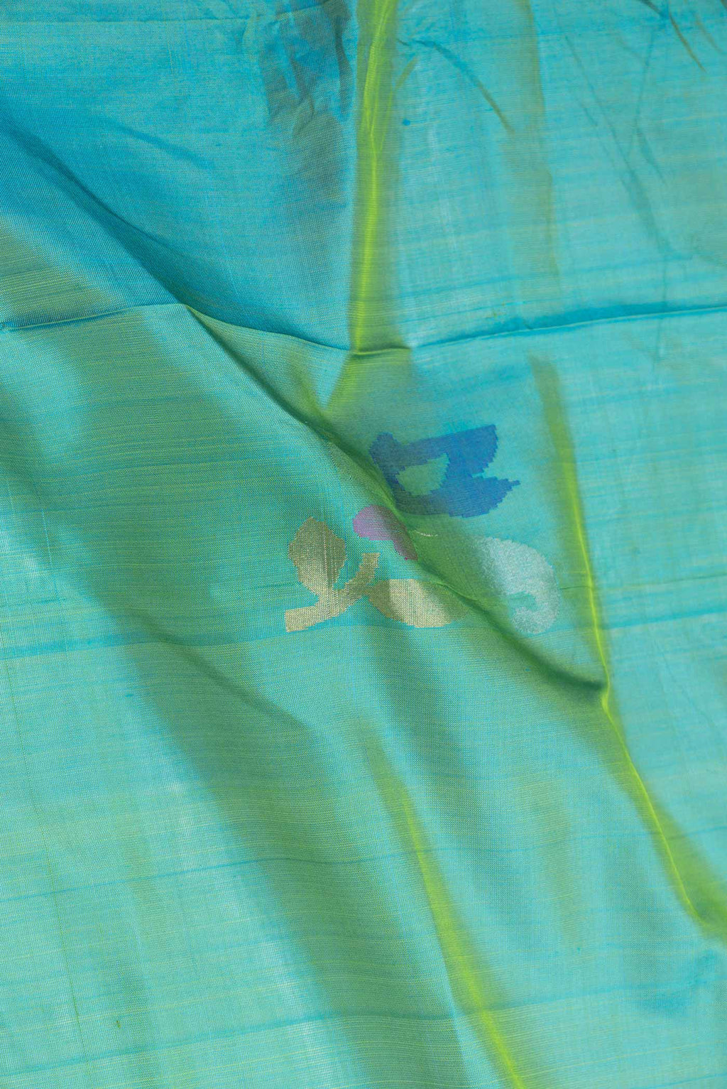Close up of Green with Blue Color Uppada Silk Saree with Zari And Thread Butta on the body and Zari Border displaying folds