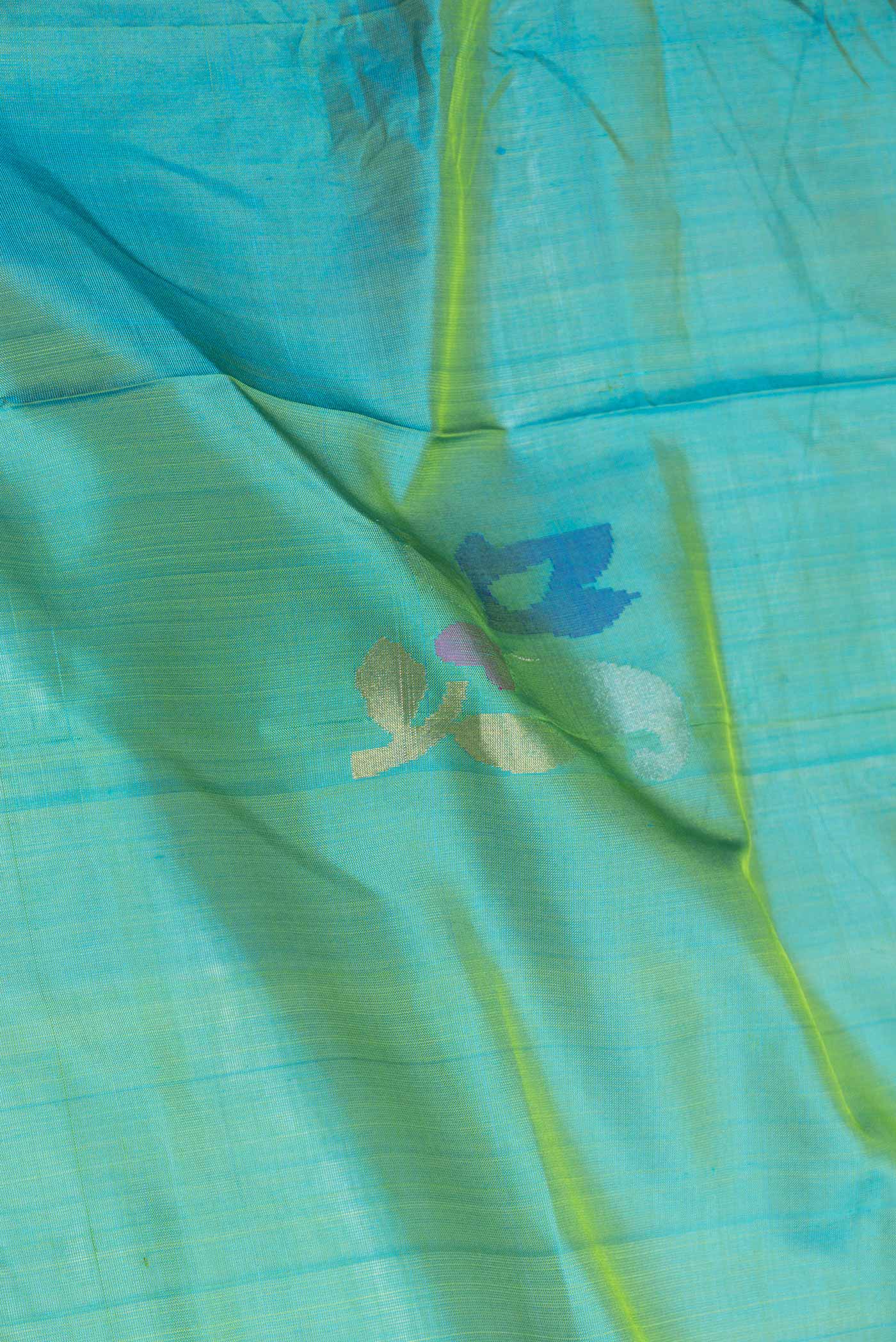 Close up of Green with Blue Color Uppada Silk Saree with Zari And Thread Butta on the body and Zari Border displaying folds