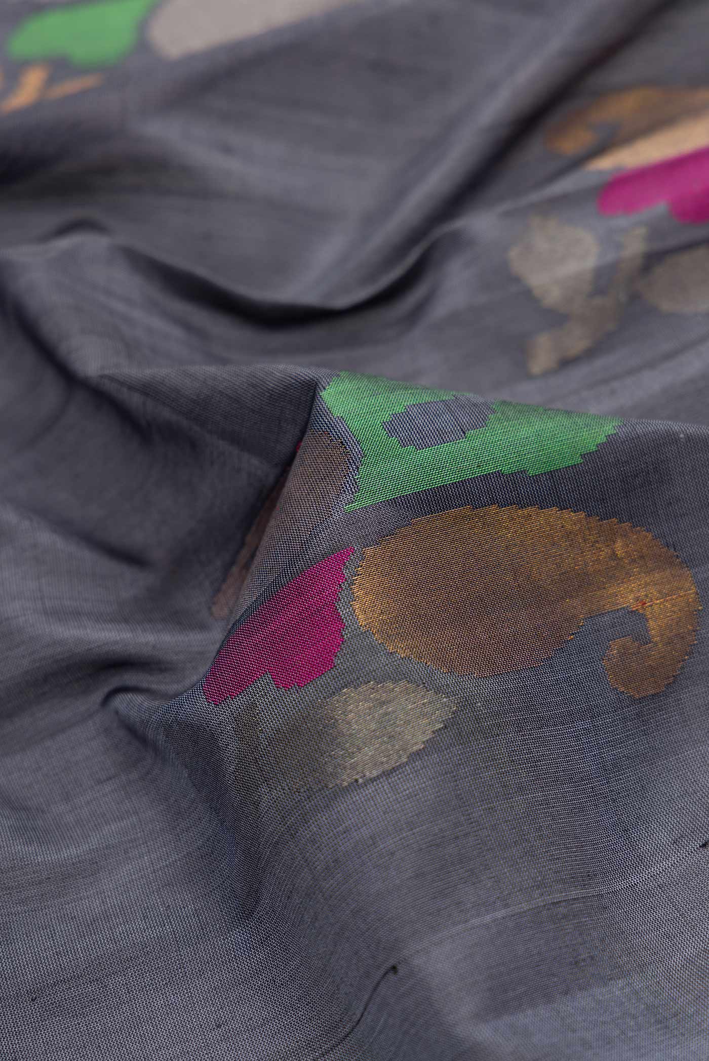 Close up of Grey Dual Tone Uppada Silk Saree with Zari And Thread Butta on the body and Zari Border.  displaying folds