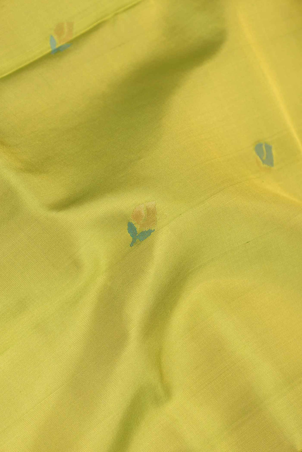 Close up of Parrot Green Dual Tone Uppada Silk Saree with Zari And Thread Butta on the body and Zari Border displaying folds