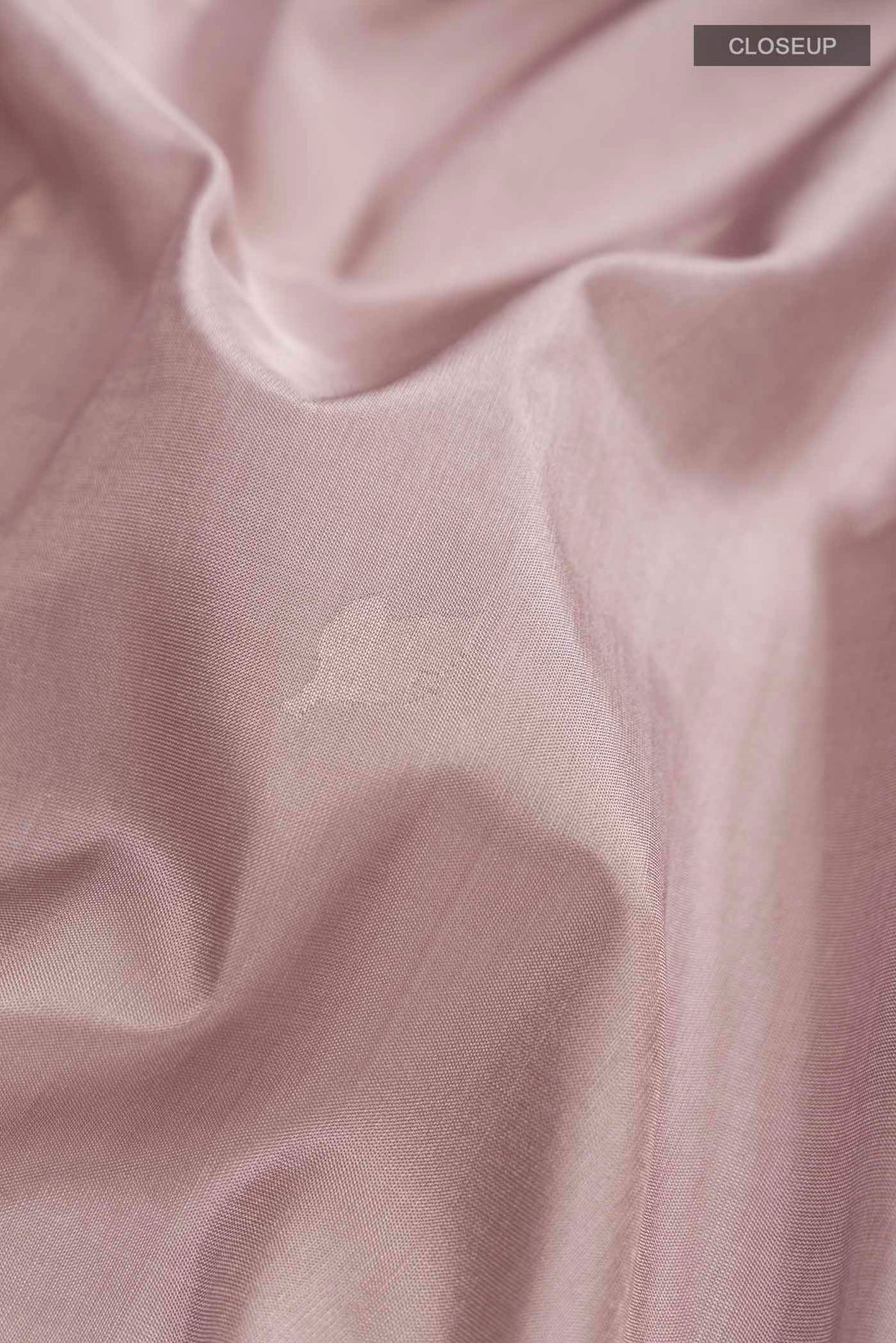 Close up of Rose Gold Dual Tone Uppada Silk Saree with Zari Butta on the body and Zari Border displaying folds