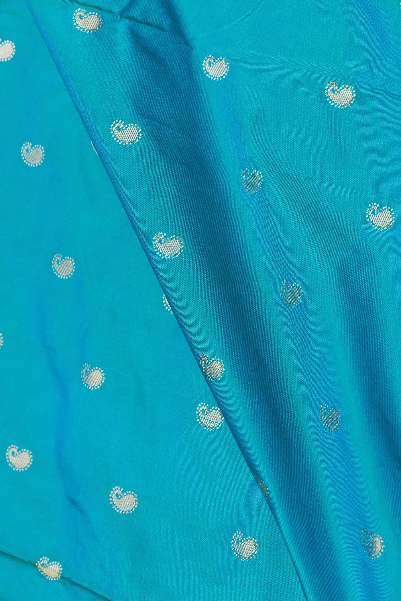 Close up of Sky Blue Dual Tone Paithani Silk Saree with Zari Butta on the body and Paithani Border displaying folds