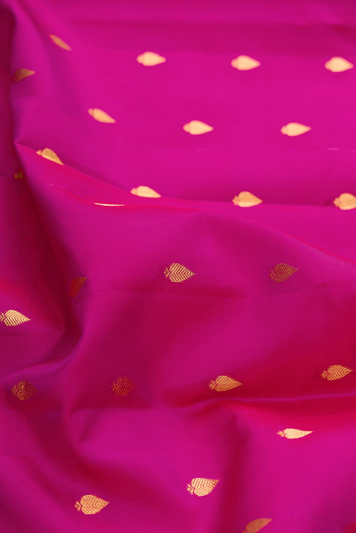 Close up of Magenta Dual Tone Kanchipuram Silk Saree with Zari Butta on the body and Zari Border displaying folds