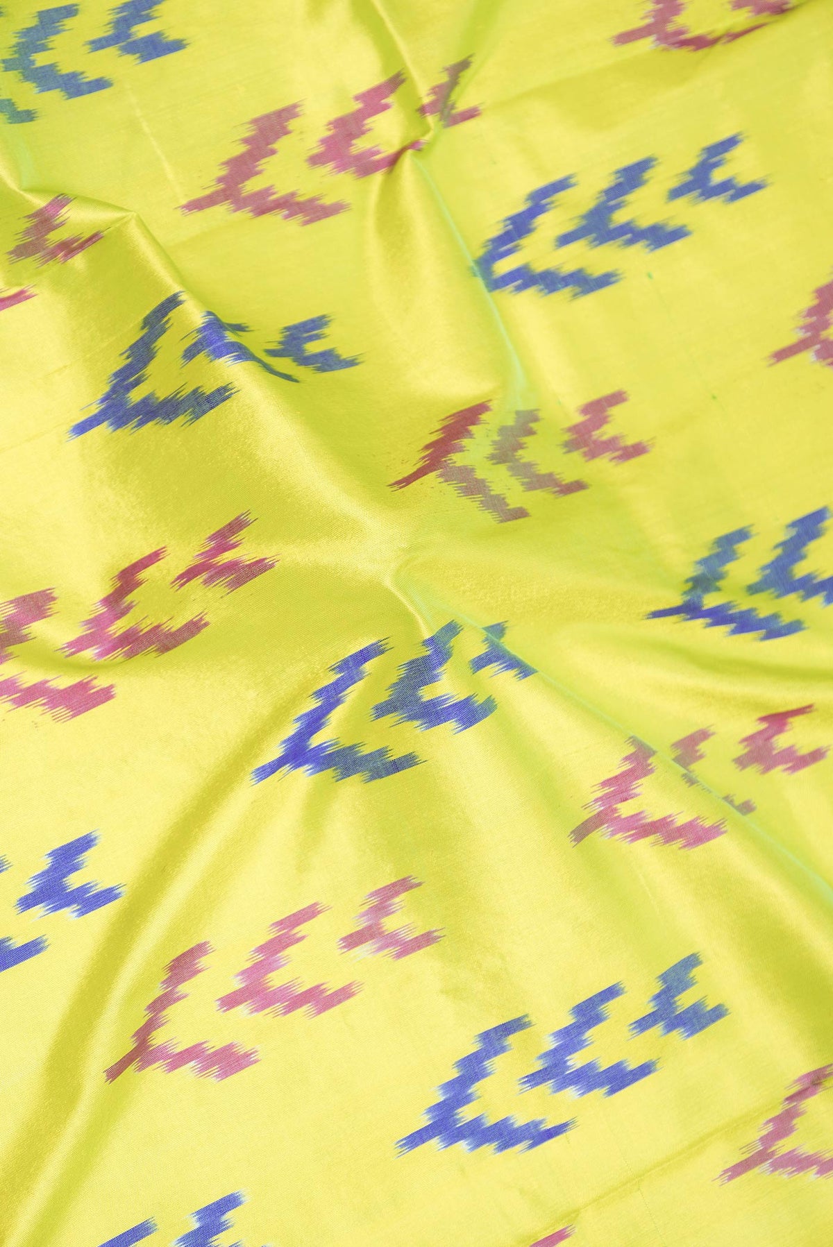 Close up of Parrot Green Dual Tone Pochampally Silk Saree with Ikat Print on the body and Ikat Border displaying folds