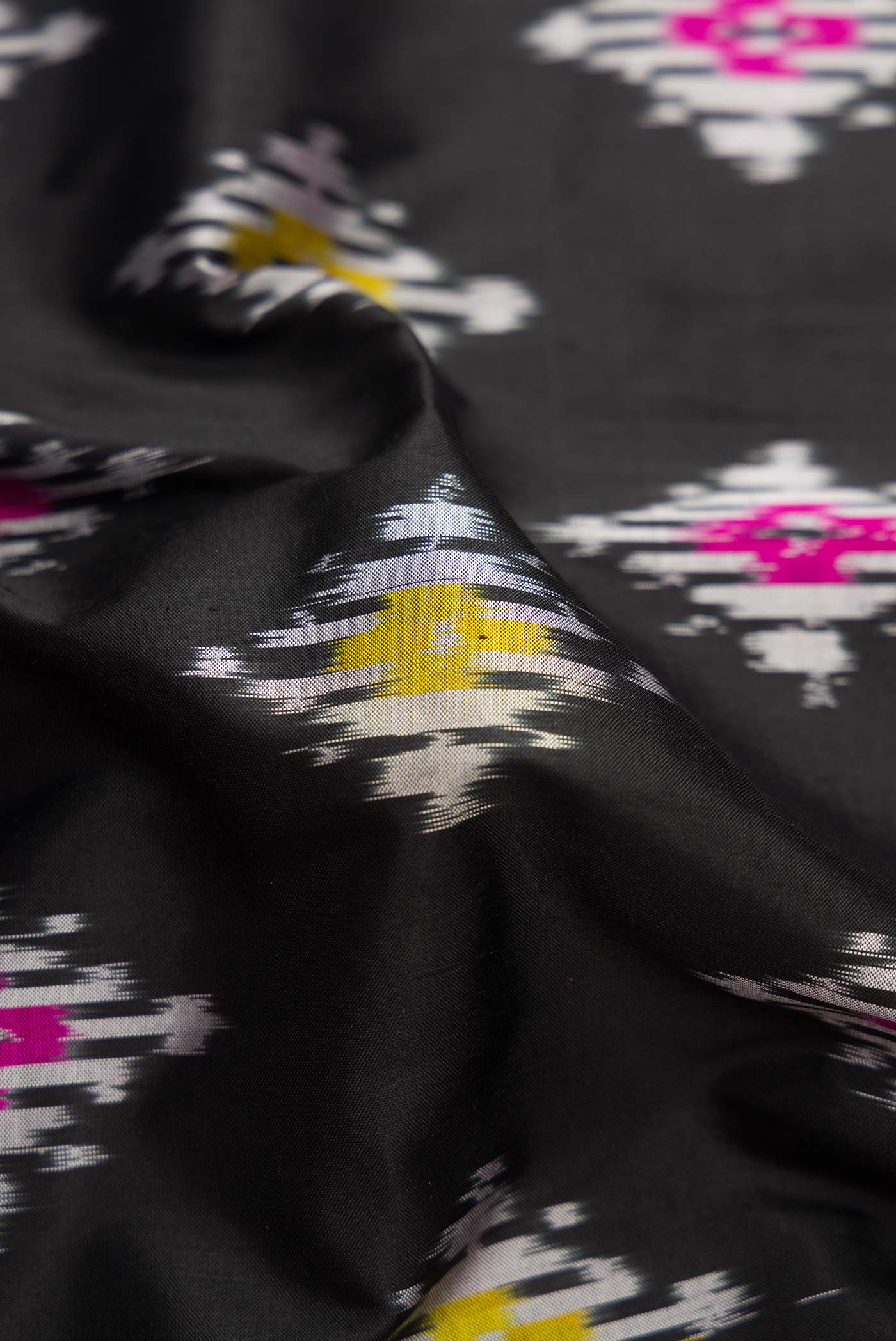 Close up of Black Dual Tone Double Ikat Saree with Ikat Print on the body and Ikat Border.  displaying folds