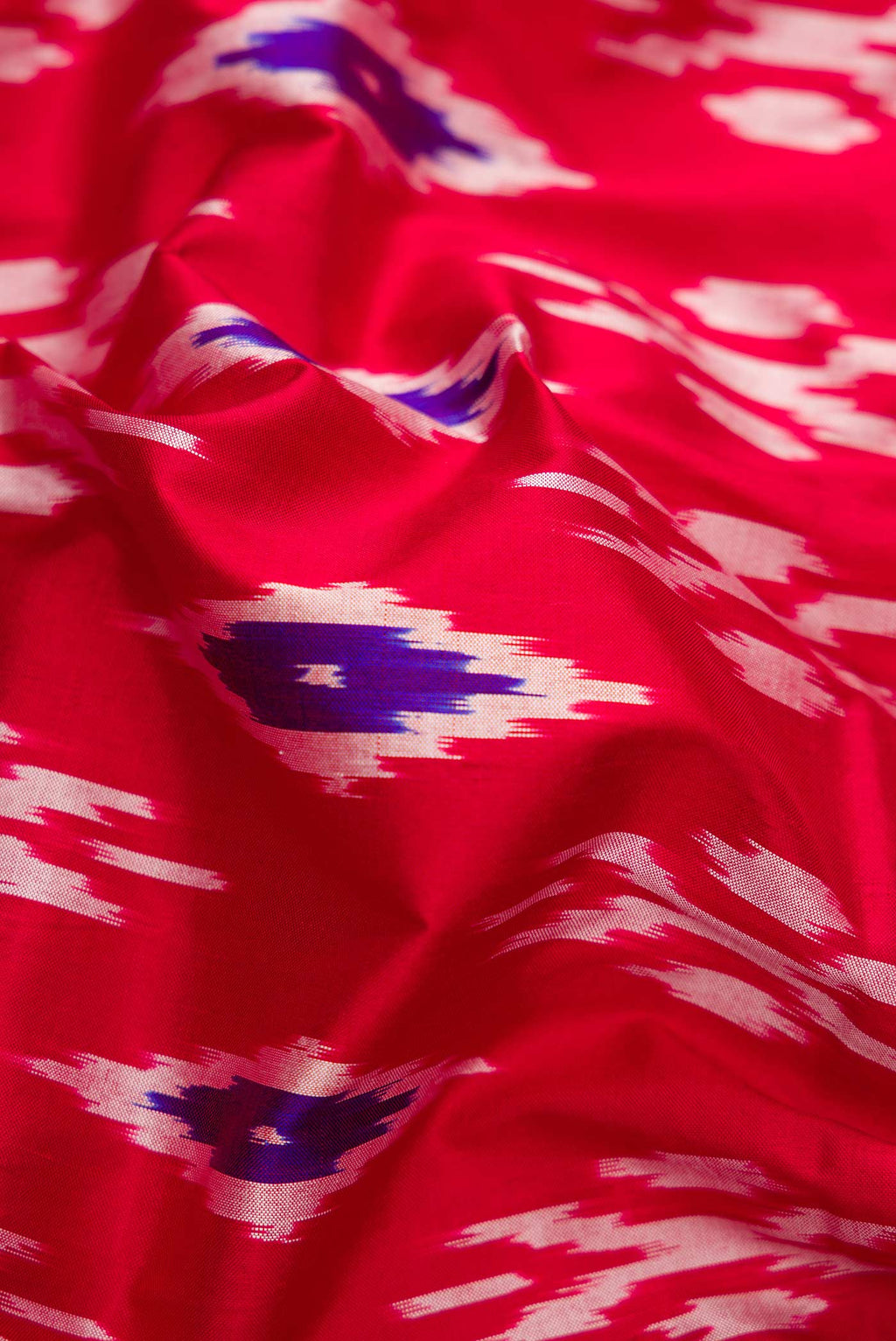 Close up of Red Dual Tone Double Ikat Saree with Ikat Print on the body and Ikat Border.  displaying folds