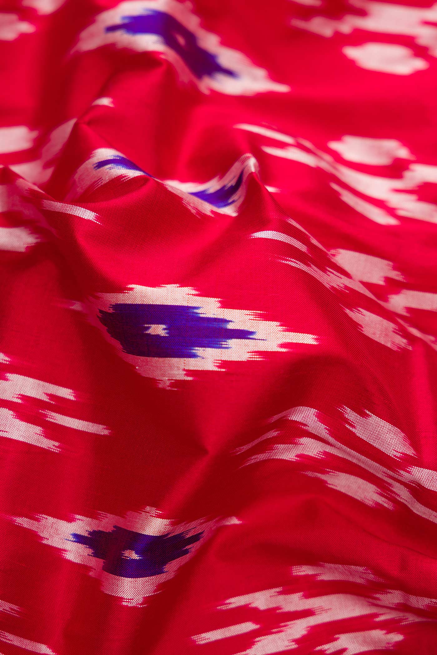 Close up of Red Dual Tone Double Ikat Saree with Ikat Print on the body and Ikat Border.  displaying folds