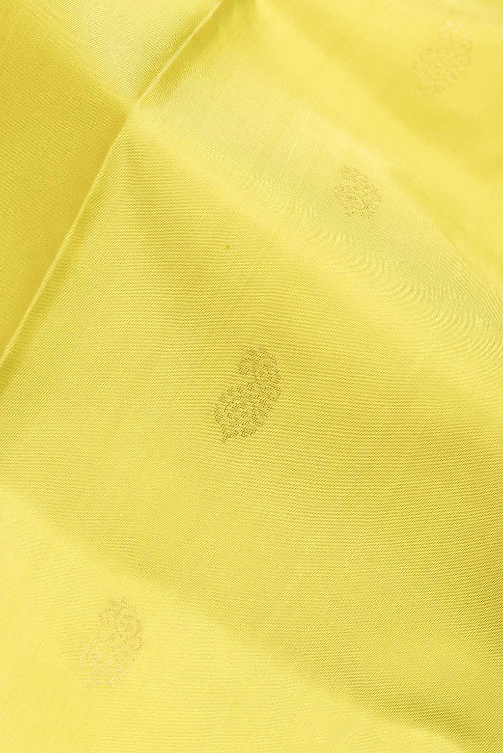 Close up of Lemon Yellow Dual Tone Soft Silk Saree with Zari Butta on the body and Fancy Border.  displaying folds