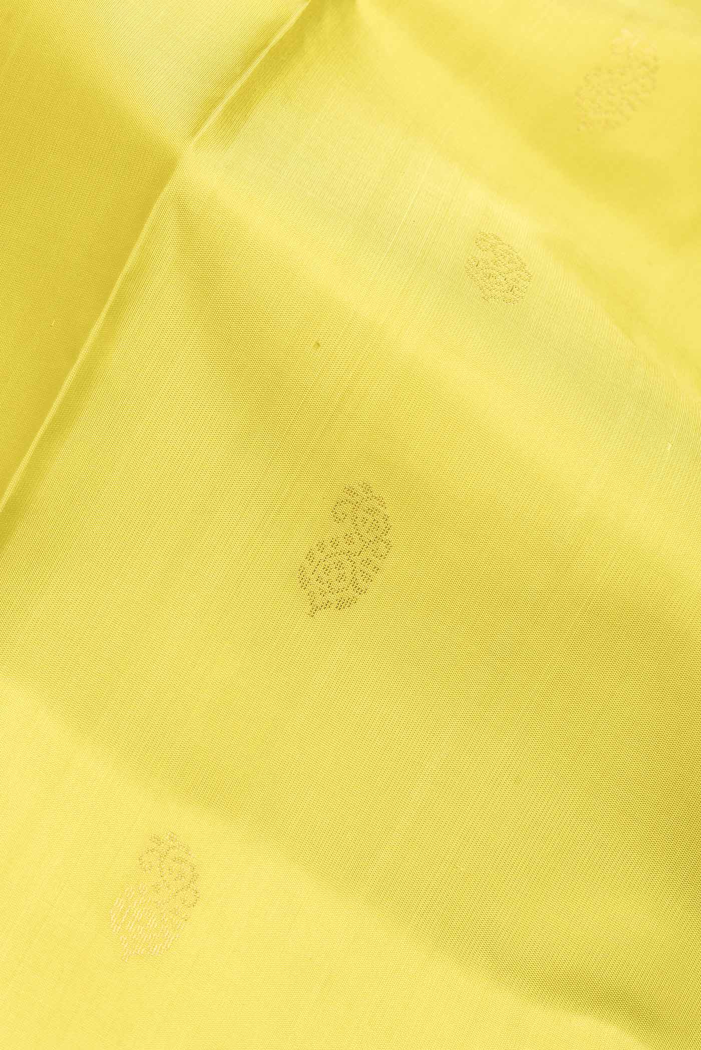Close up of Lemon Yellow Dual Tone Soft Silk Saree with Zari Butta on the body and Fancy Border.  displaying folds
