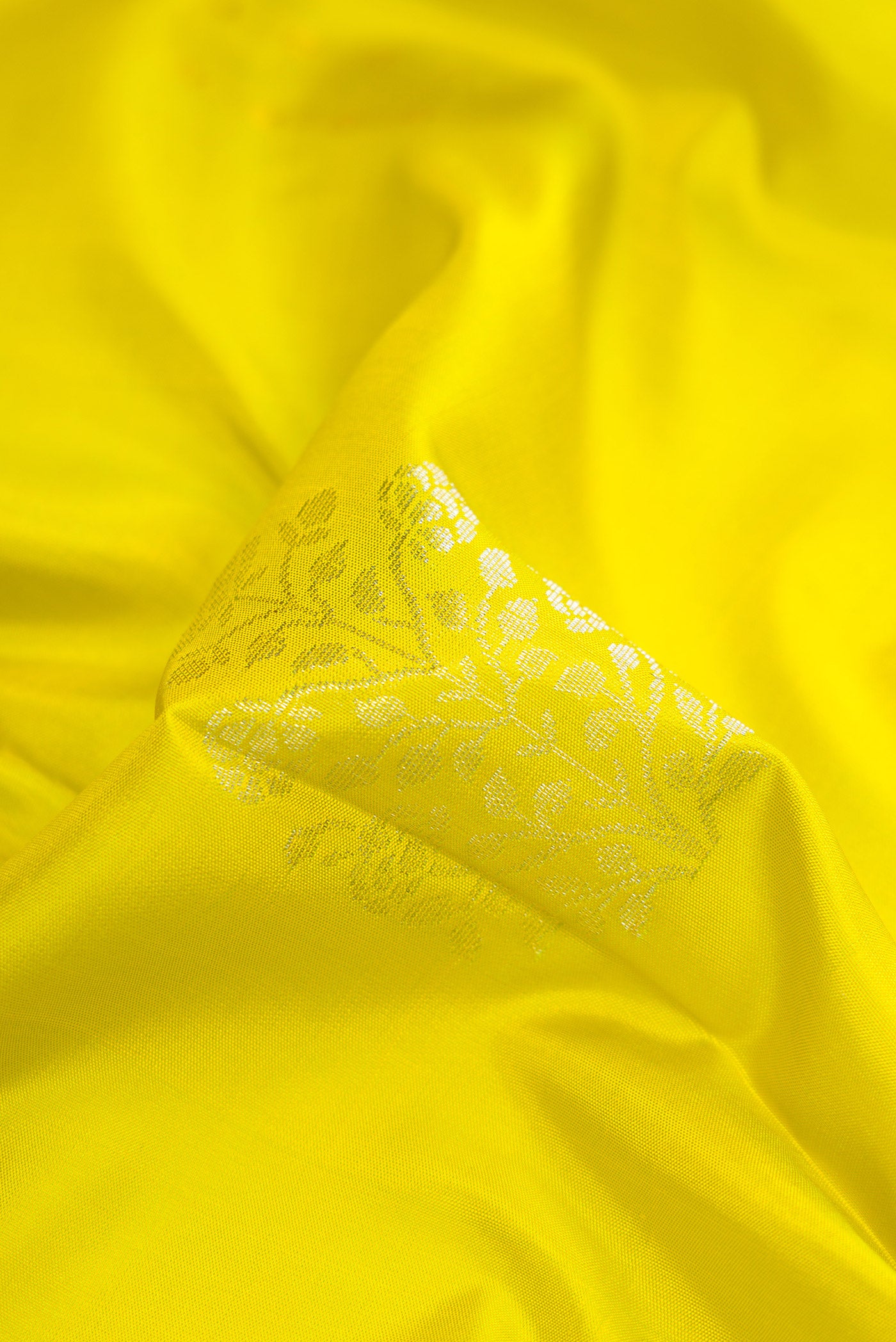Close up of Parrot Green Dual Tone Soft Silk Saree with Zari Butta on the body and Zari Border.  displaying folds