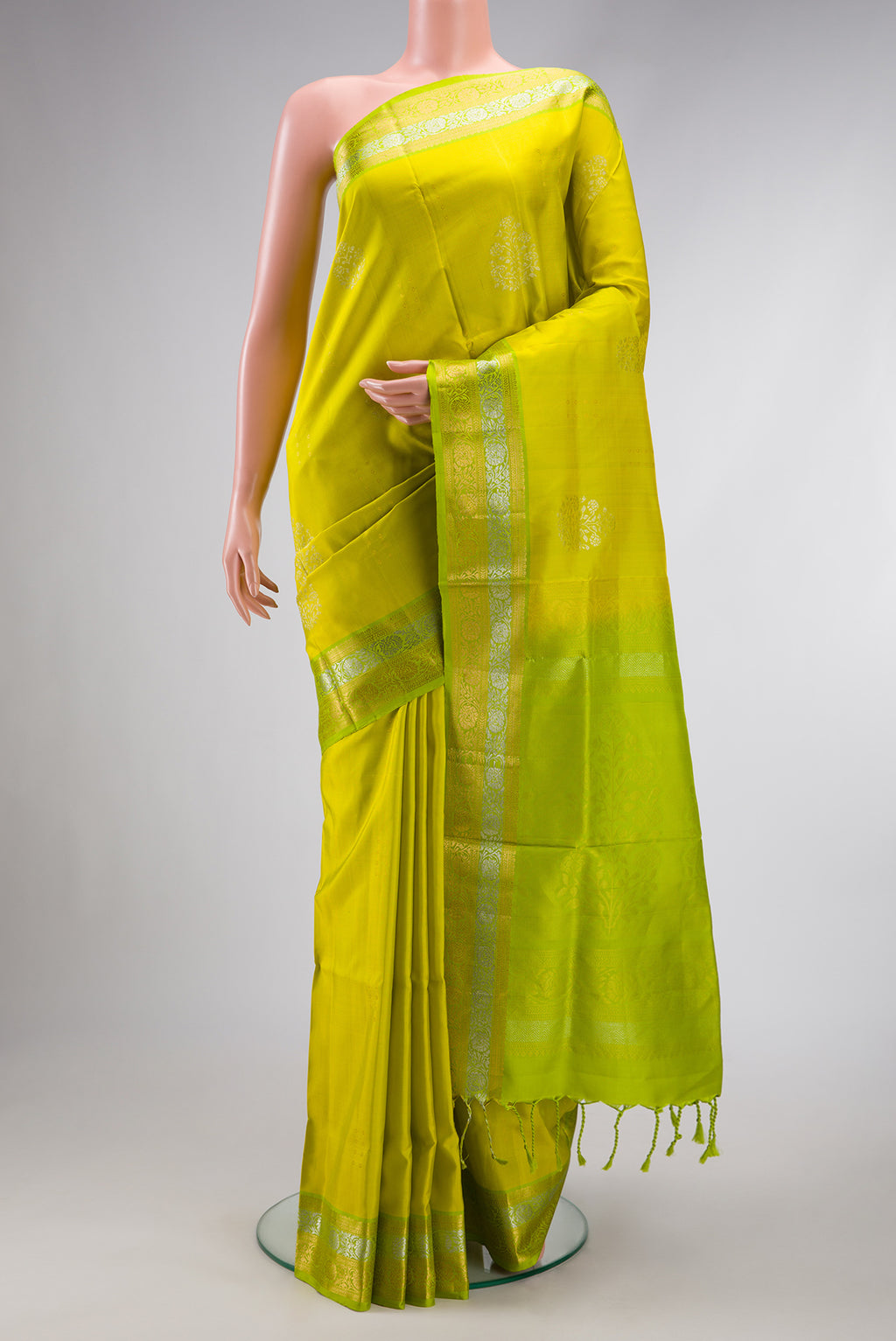 Parrot Green Dual Tone Soft Silk Saree with Zari Butta on the body and Zari Border.  displayed on a mannequin