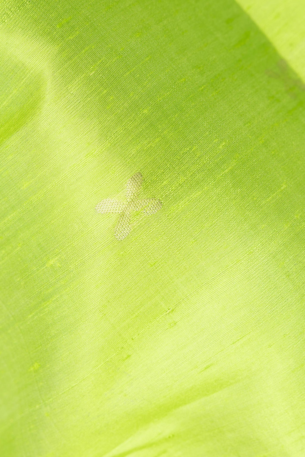 Close up of Parrot Green Raw Saree with Zari Butta on the body and Zari Border.  displaying folds