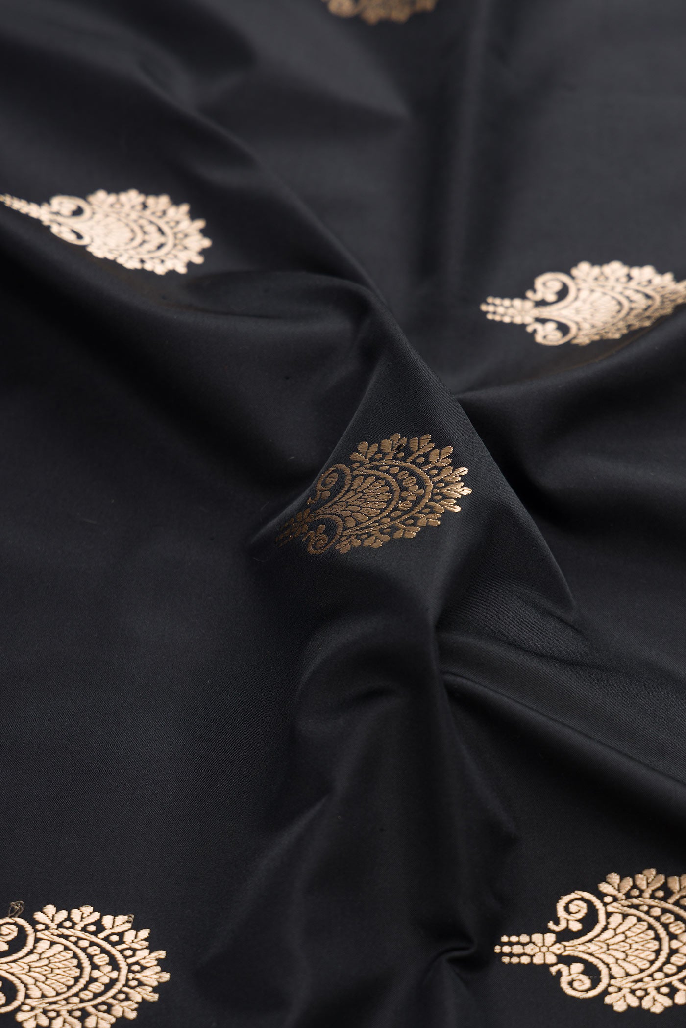 Close up of Black Banarasi Silk Saree with Zari Butta on the body and Zari Border displaying folds