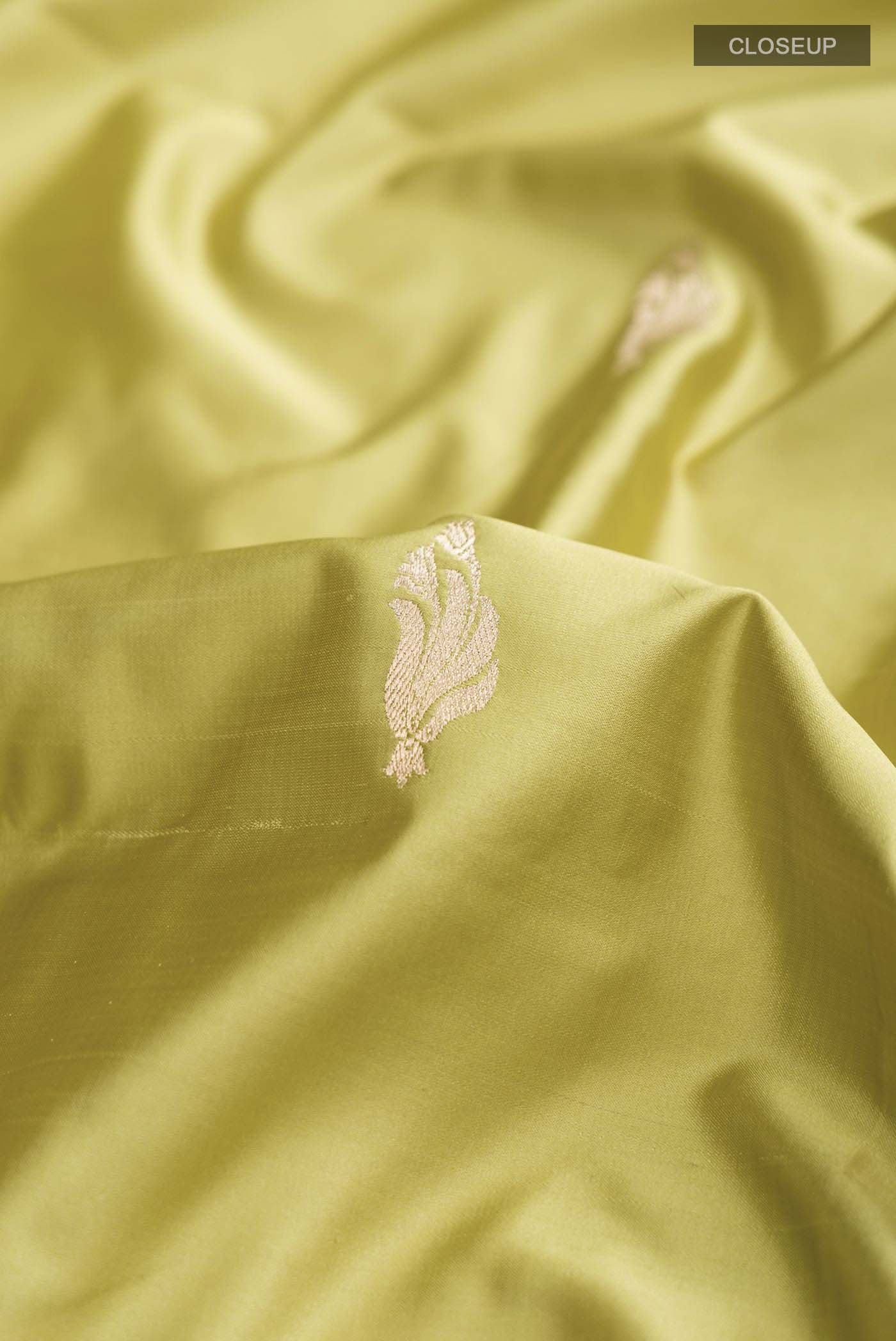 Close up of Green Banarasi Silk Saree with Zari Butta on the body and Zari Border displaying folds