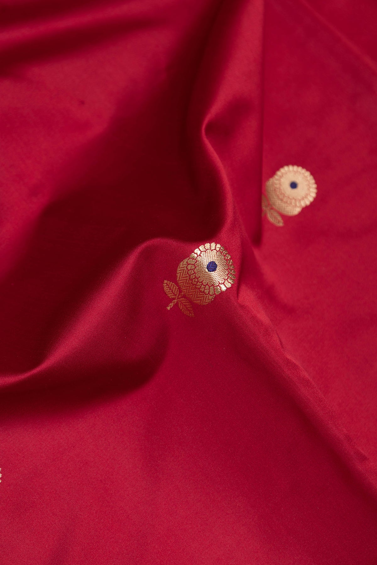 Close up of Maroon Dual Tone Banarasi Silk Saree with Zari And Thread Butta on the body and Zari Border.  displaying folds