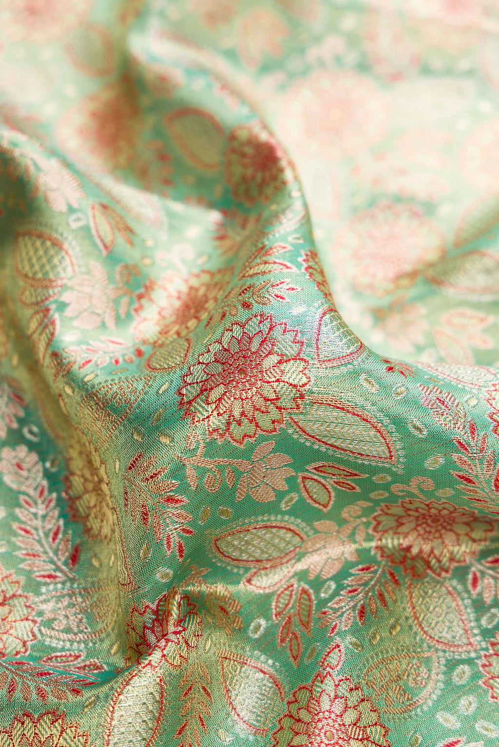 Close up of Green Dual Tone Kanchipuram Tissue Silk Saree with Zari Brocade on the body and Zari Border.  displaying folds