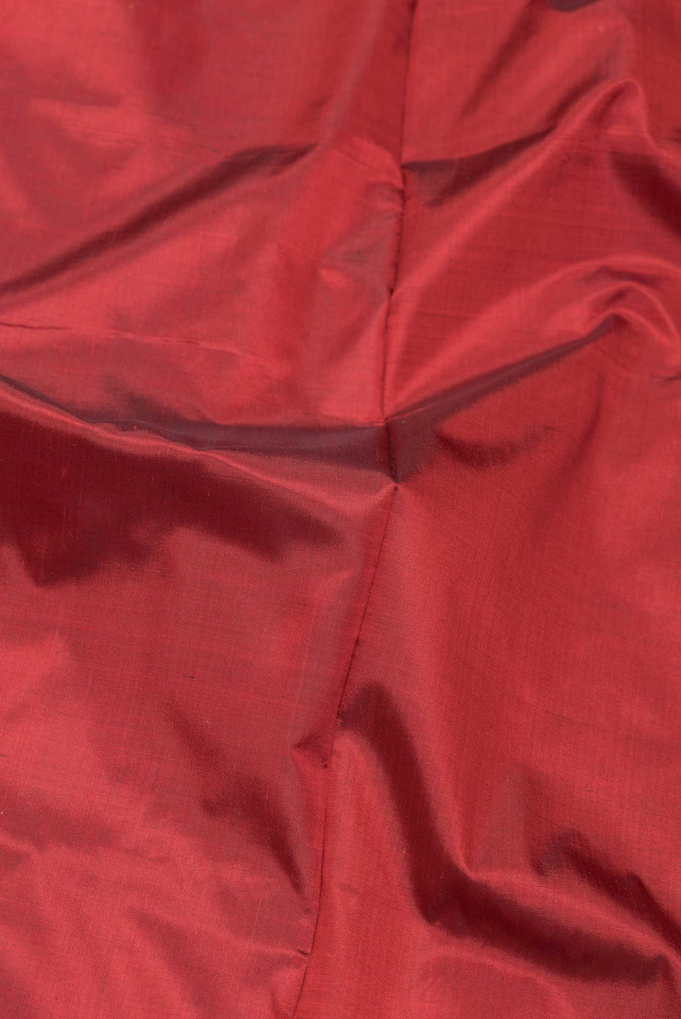 Close up of Maroon Dual Tone Banarasi Silk Saree with Plain Body and Zari And Thread Border.  displaying folds