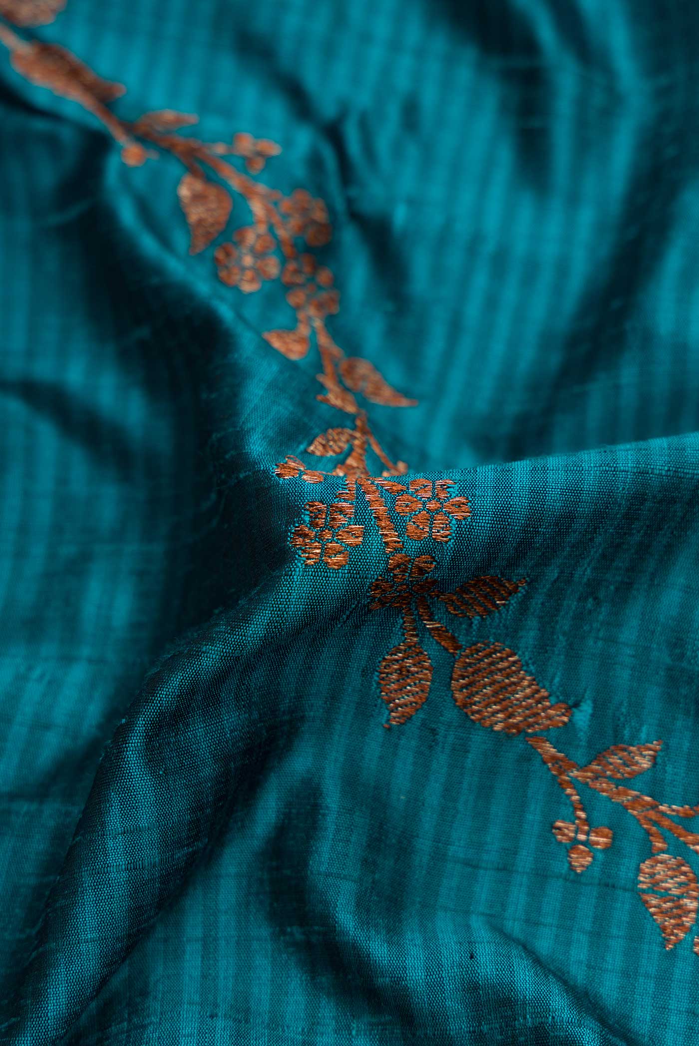 Close up of Maya Blue Banarasi Tussar Silk Saree with Zari Butta on the body and Zari Border displaying folds