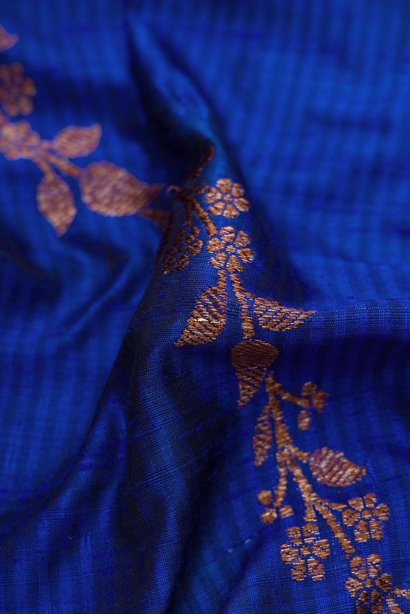 Close up of Royal Blue Banarasi Tussar Silk Saree with Zari Butta on the body and Zari Border displaying folds