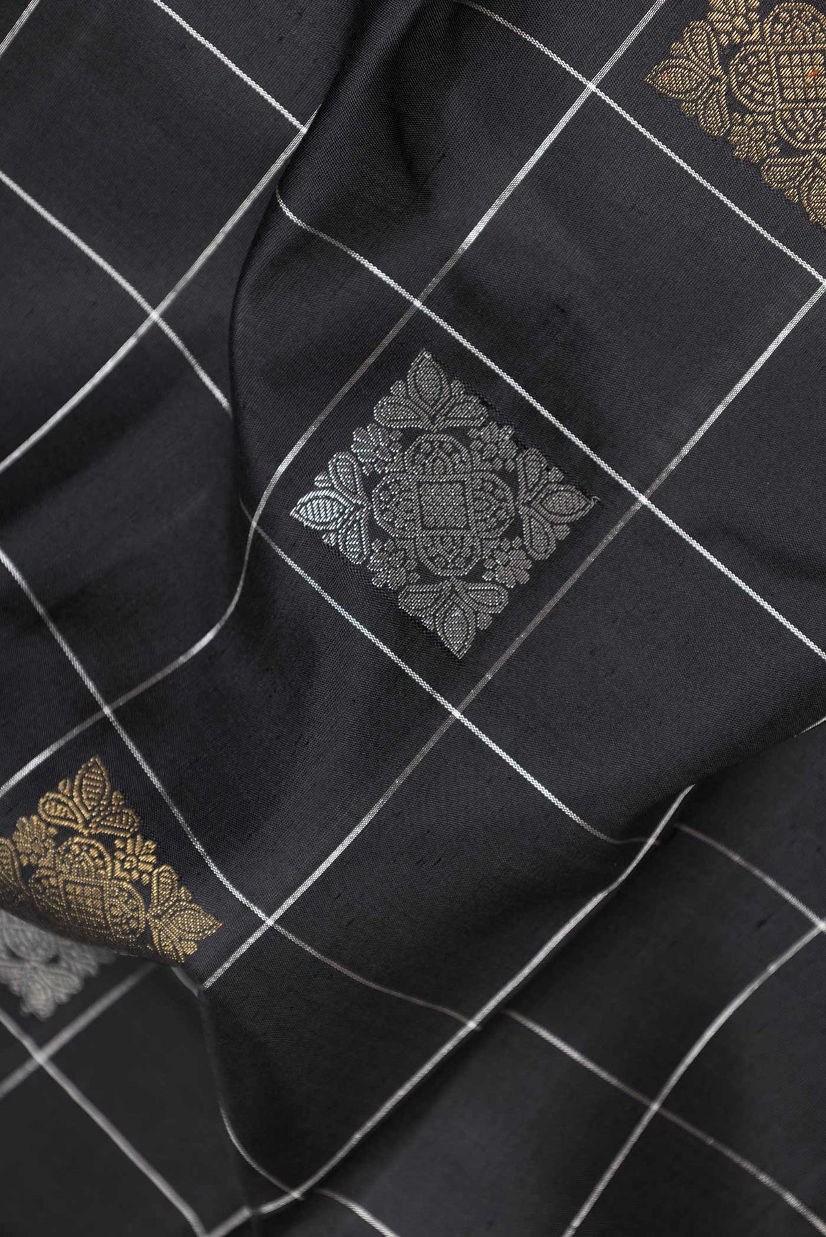 Close up of Pure Silk Pure Zari Black Dual Tone Kanchipuram Saree with Checked design on the body and Zari Border displaying folds