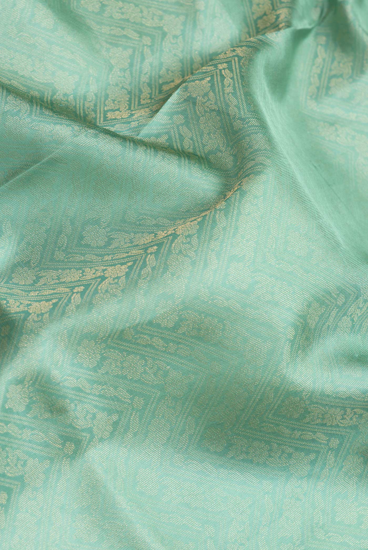 Close up of Sea Green Dual Tone Soft Silk Saree with Zari Brocade on the body and Zari Border.  displaying folds