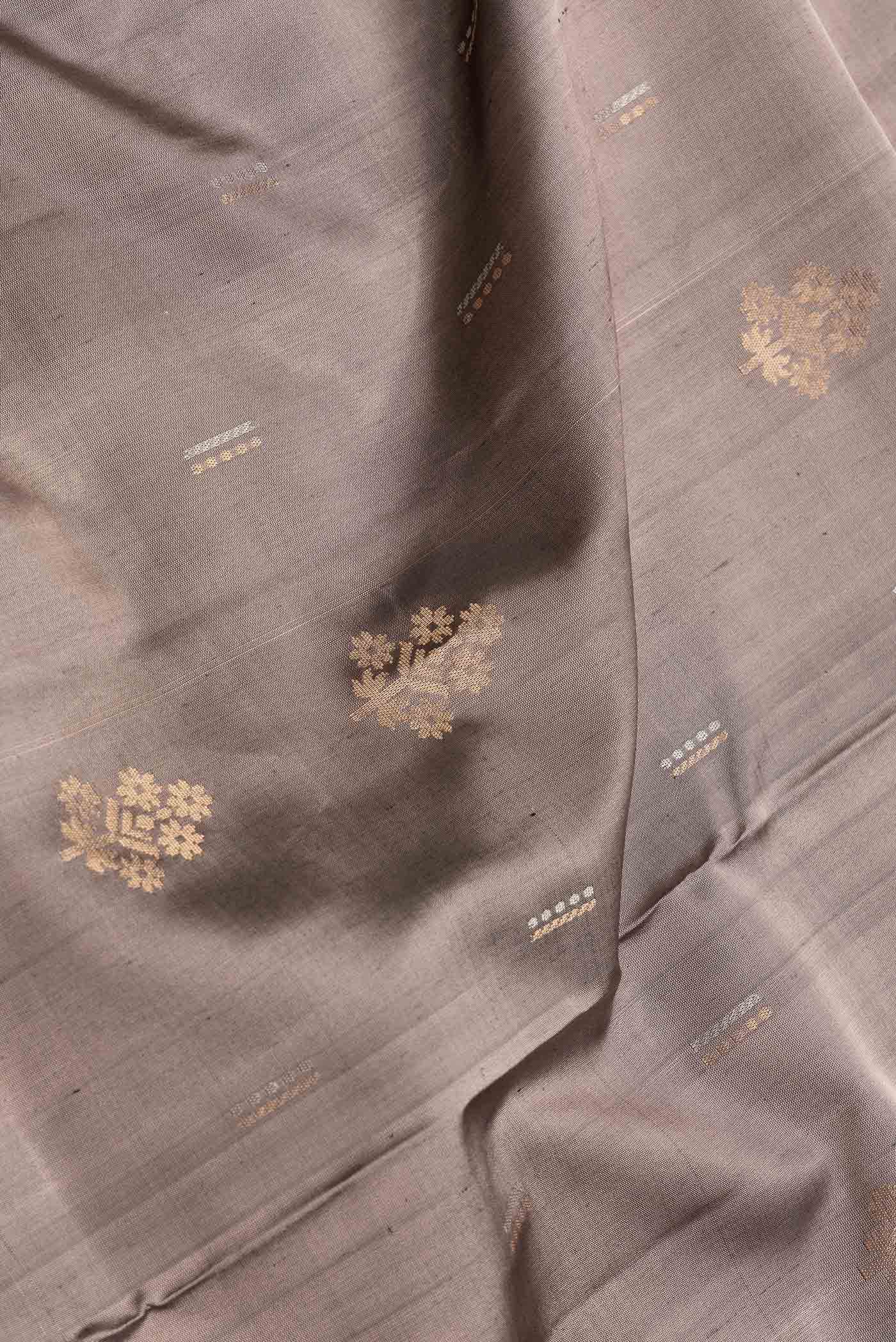 Close up of Grey Dual Tone Soft Silk Saree with Zari Butta on the body and Zari Border.  displaying folds