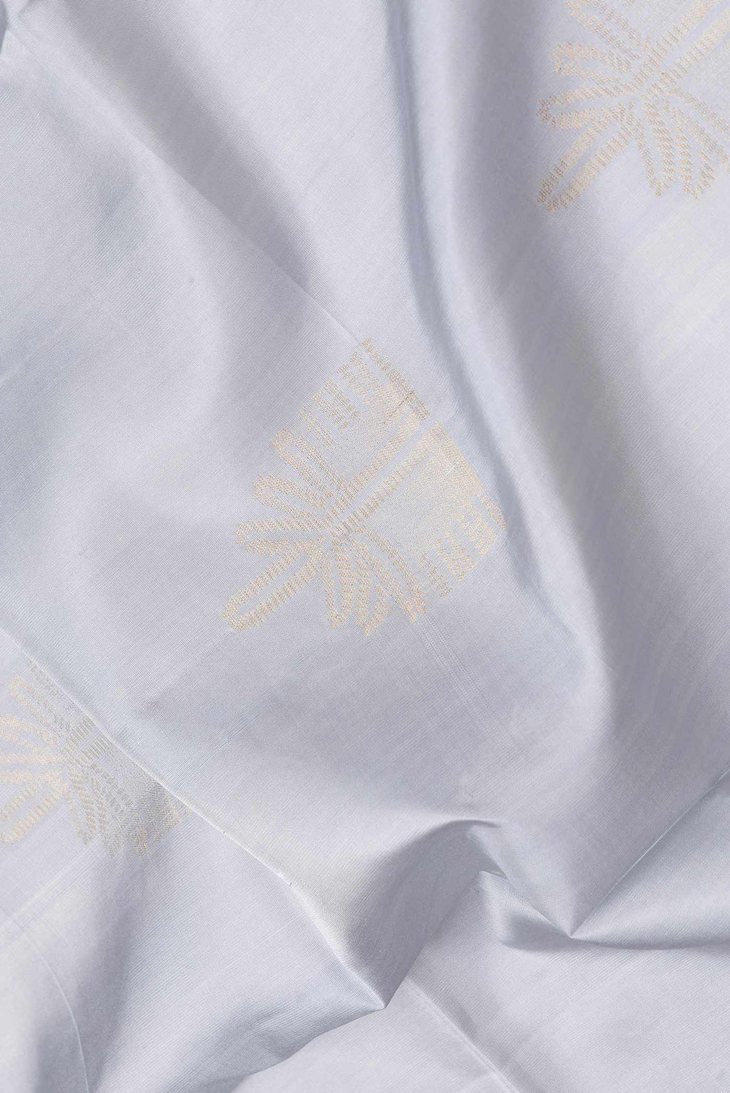 Close up of Grey Dual Tone Soft Silk Saree with Zari Butta on the body and Zari Border.  displaying folds
