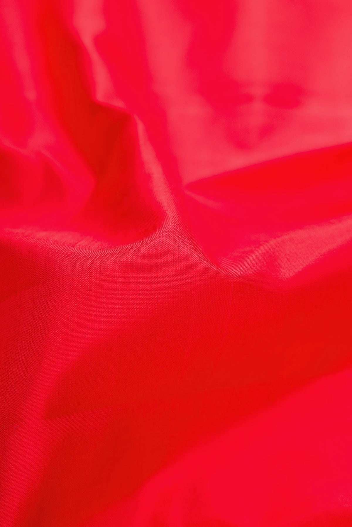 Close up of Red Dual Tone Kanjivaram Silk Saree with Plain Body and Zari Border.  displaying folds