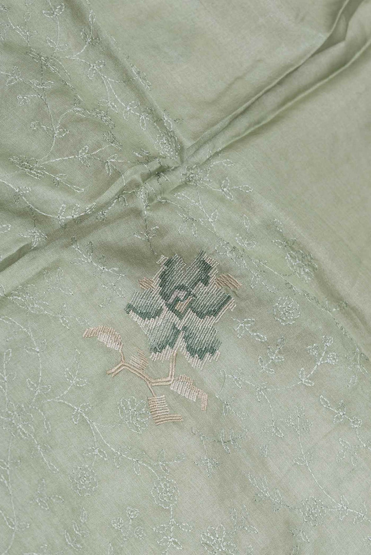 Close up of Green Dual Tone Tussar Saree with Embroidery on the body and Embroidery Border displaying folds