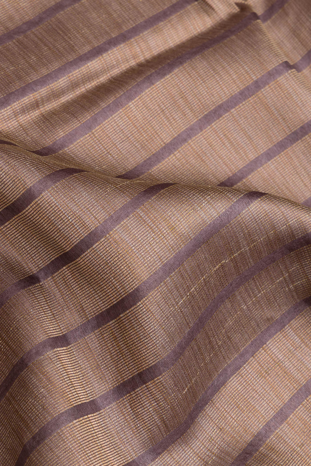 Close up of Brown Dual Tone Tussar Silk Saree with Stripes on the body and Embroidery Border.  displaying folds