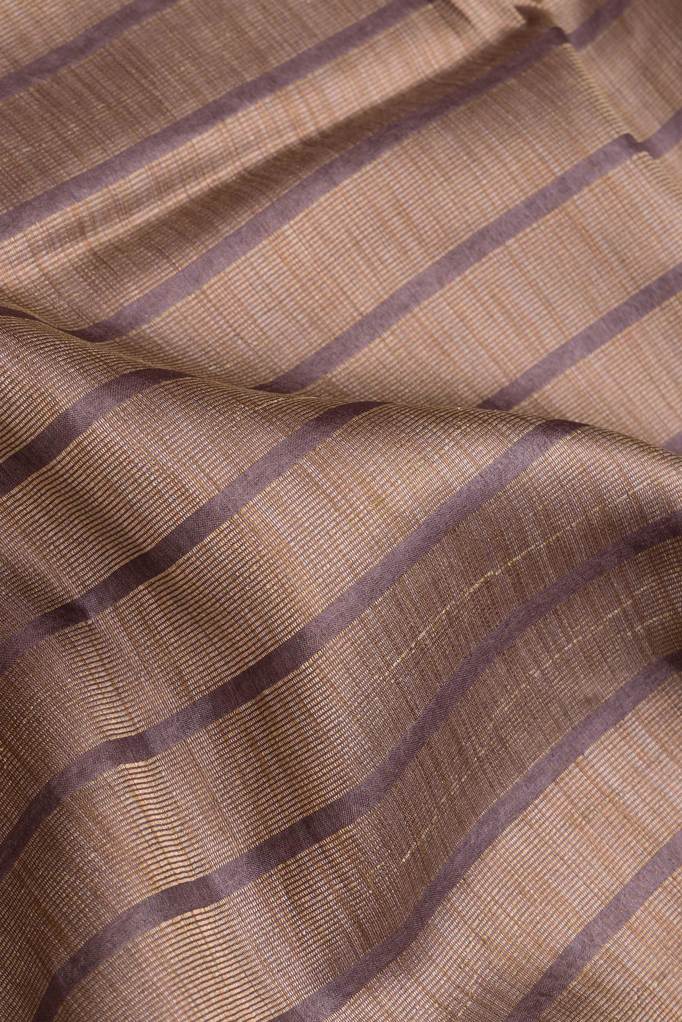 Close up of Brown Dual Tone Tussar Silk Saree with Stripes on the body and Embroidery Border.  displaying folds
