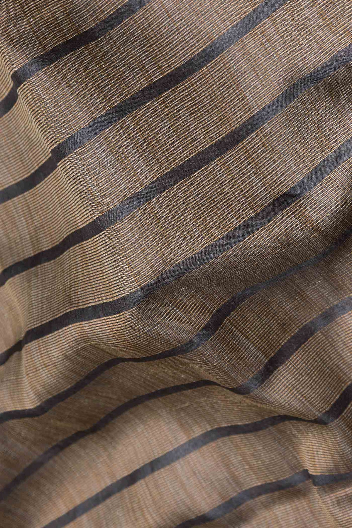 Close up of Black Dual Tone Tussar Silk Saree with Stripes on the body and Embroidery Border displaying folds