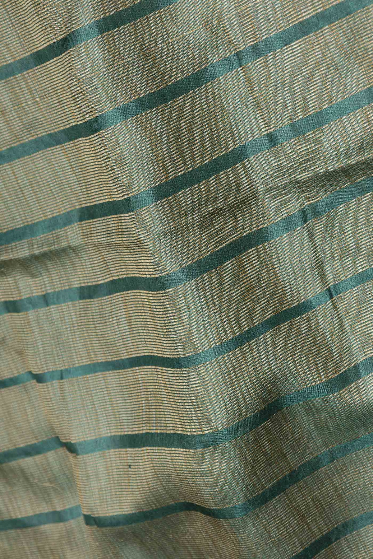 Close up of Green Dual Tone Tussar Silk Saree with Stripes on the body and Embroidery Border displaying folds