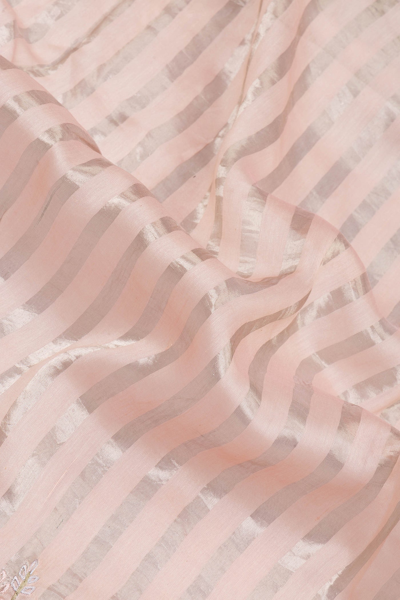 Close up of Rose pink Tussar Silk Saree with Stripes on the body and Embroidery Border.  displaying folds