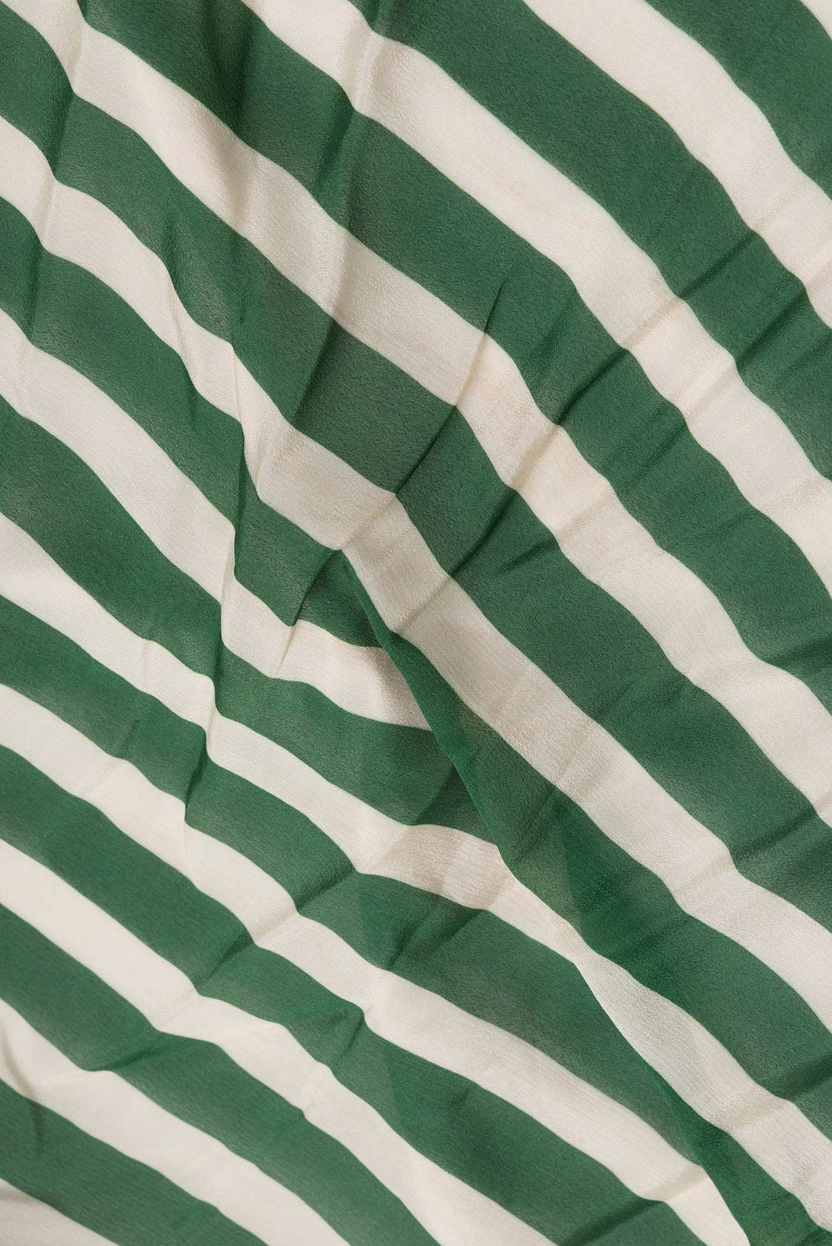 Close up of Off White and Green Color Mysore Crepe Saree with Printed design on the body and Embroidery Border.  displaying folds