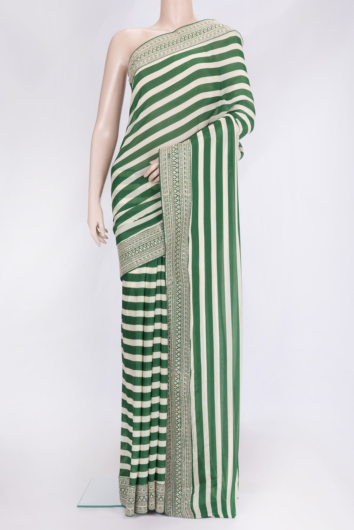 Off White and Green Color Mysore Crepe Saree with Printed design on the body and Embroidery Border.  displayed on a mannequin